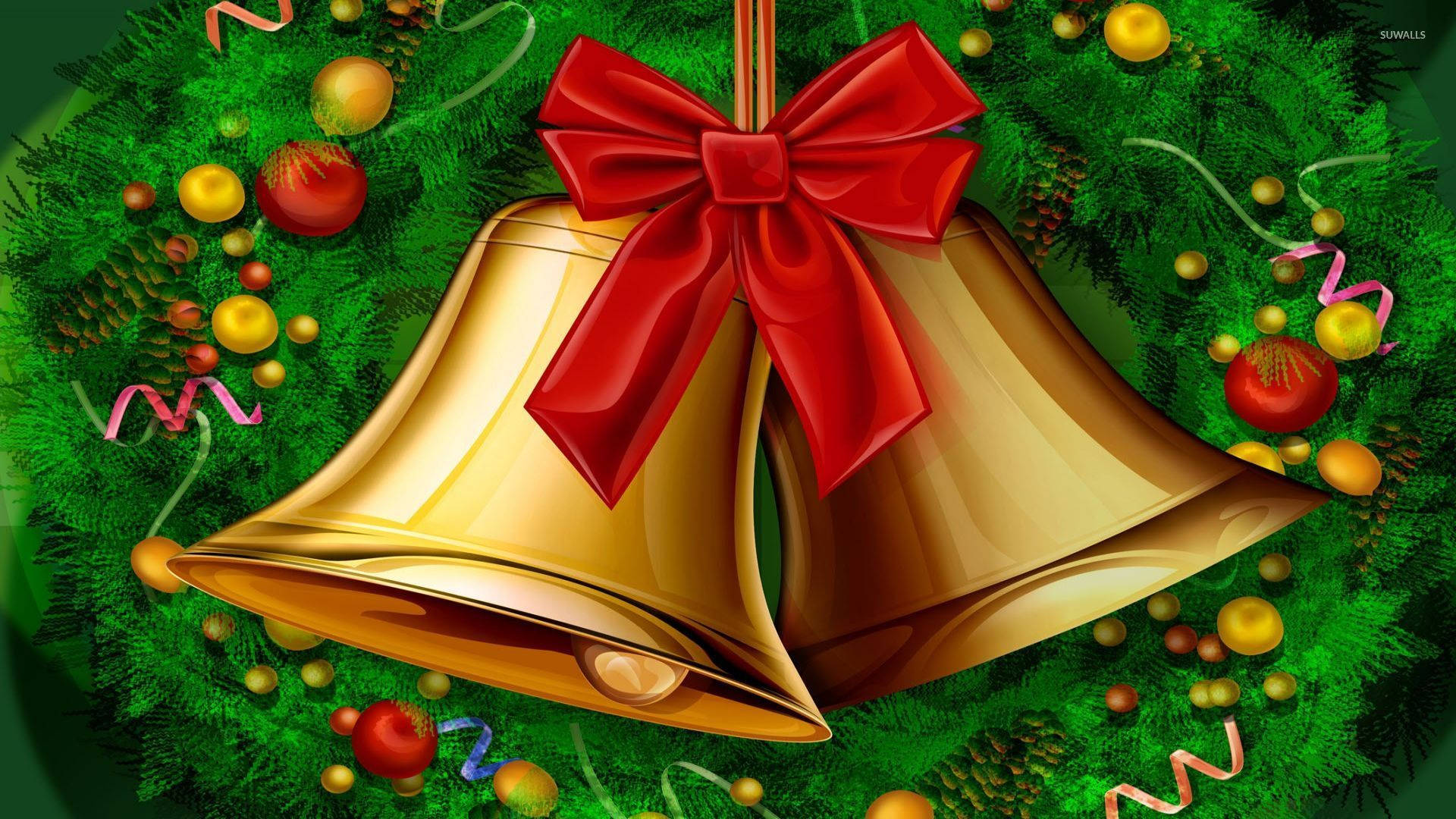 Christmas Bell 桌布 壁紙 — 兩個閃亮的金色鈴鐺繫著紅色蝴蝶結，放在一個裝飾著松果和彩色飾品的茂盛綠色花環中。