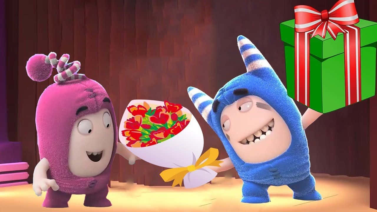 Oddbods 桌布 壁紙 — 兩個開心的卡通角色，一個粉紅色一個藍色，交換一束紅色鬱金香和一個附有紅色蝴蝶結的綠色禮物盒。