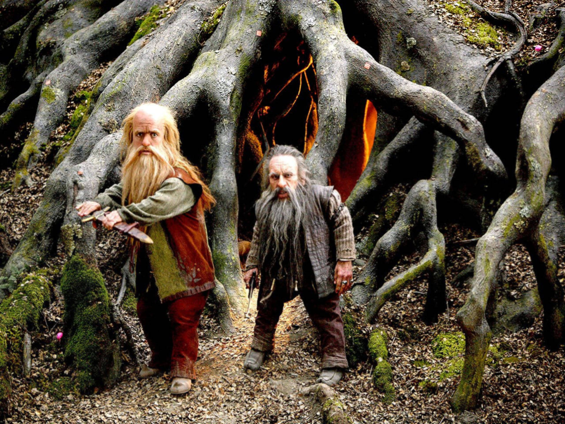 Narnia 桌布 壁紙 — 兩個鬍鬚矮人站在一個散發溫暖光芒的巨大樹根洞穴前。