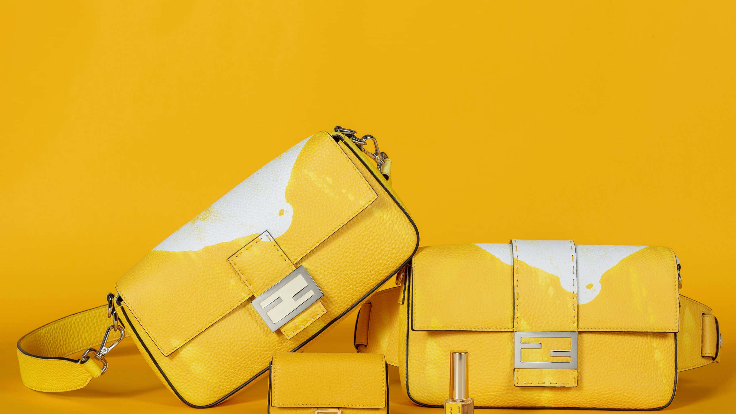 Fendi 桌布 壁紙 — 兩個鮮黃色Fendi手提包，帶有白色油漆潑濺設計，放在純黃色背景上。