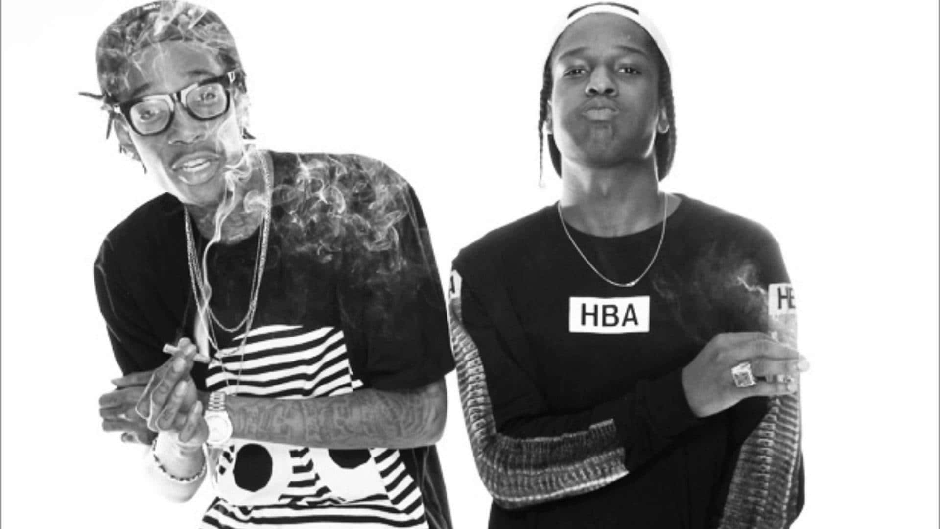 ASAP Rocky 桌布 壁紙 — 兩個黑白男子在純白背景前擺姿勢，香煙冒出的煙霧裊裊升起。