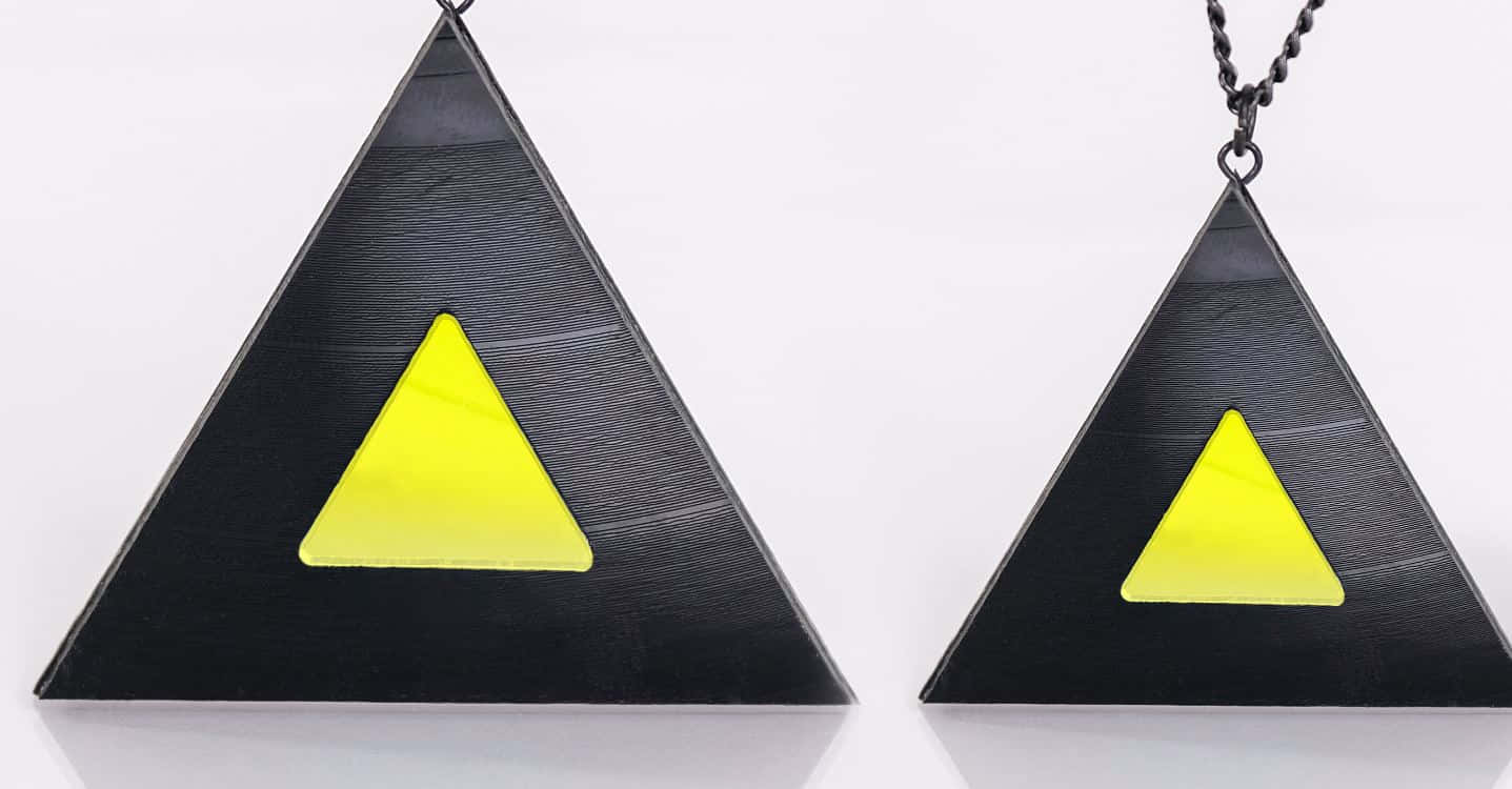 Yellow Triangle 桌布 壁紙 — 兩個黑色三角形吊墜，帶有明亮的黃色內三角形，懸掛在潔白的背景上。