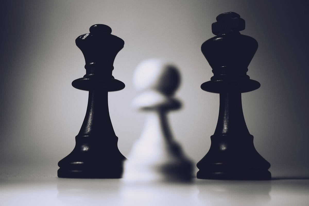 西洋棋 桌布 壁紙 — 兩個黑色國王棋夾著一個模糊的白色兵卒，構成鮮明的單色構圖。