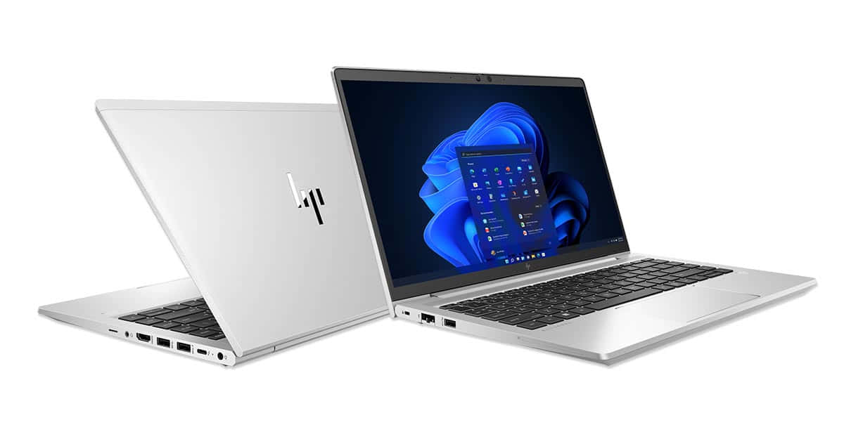 HP 桌布 壁紙 — 兩台銀色HP筆記型電腦傾斜在白色背景上，一台打開顯示Windows 11藍色抽象桌布。