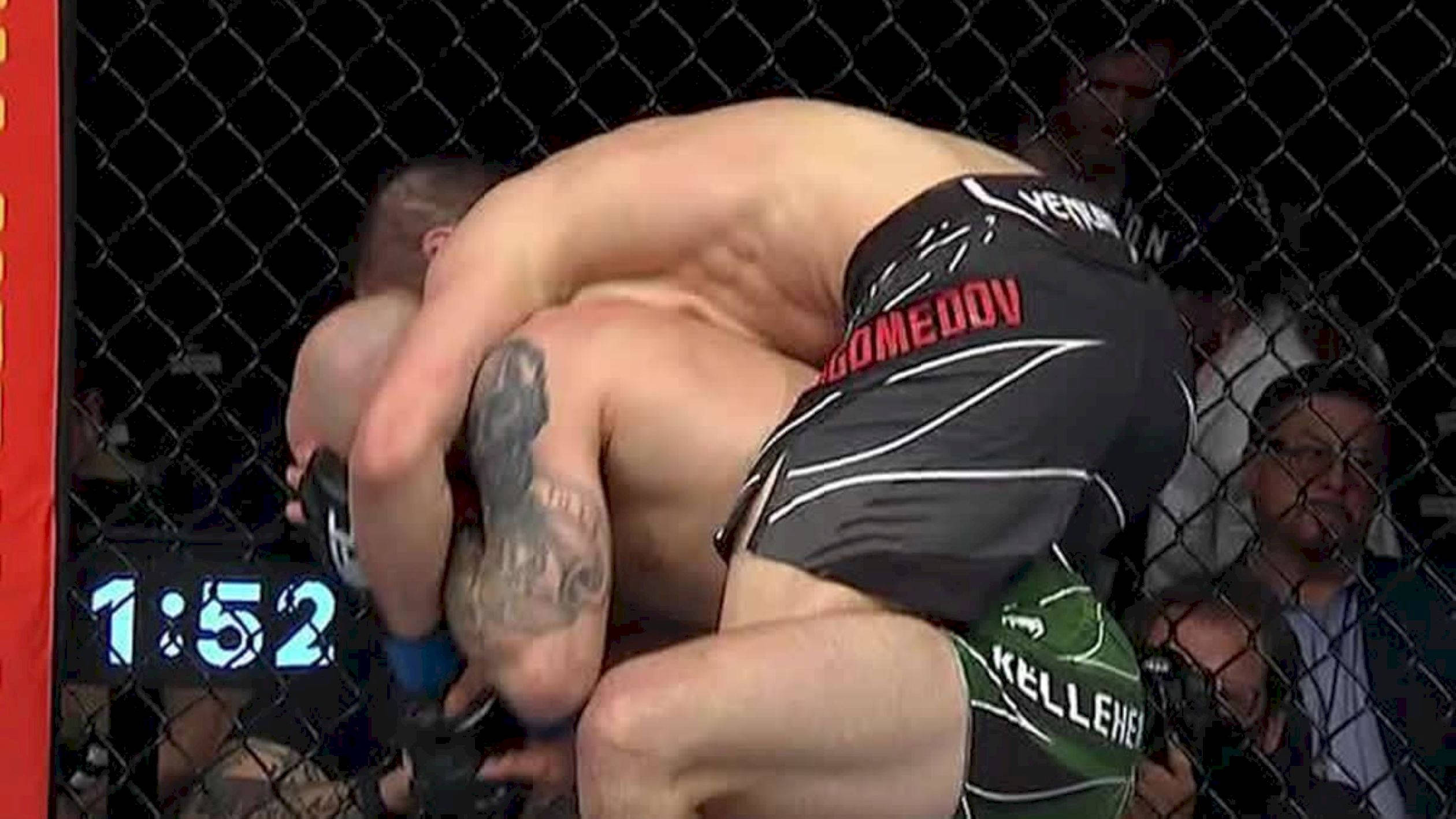 UFC 桌布 壁紙 — 兩名MMA拳手在八角籠內激烈纏鬥，數位計時器顯示1:52。