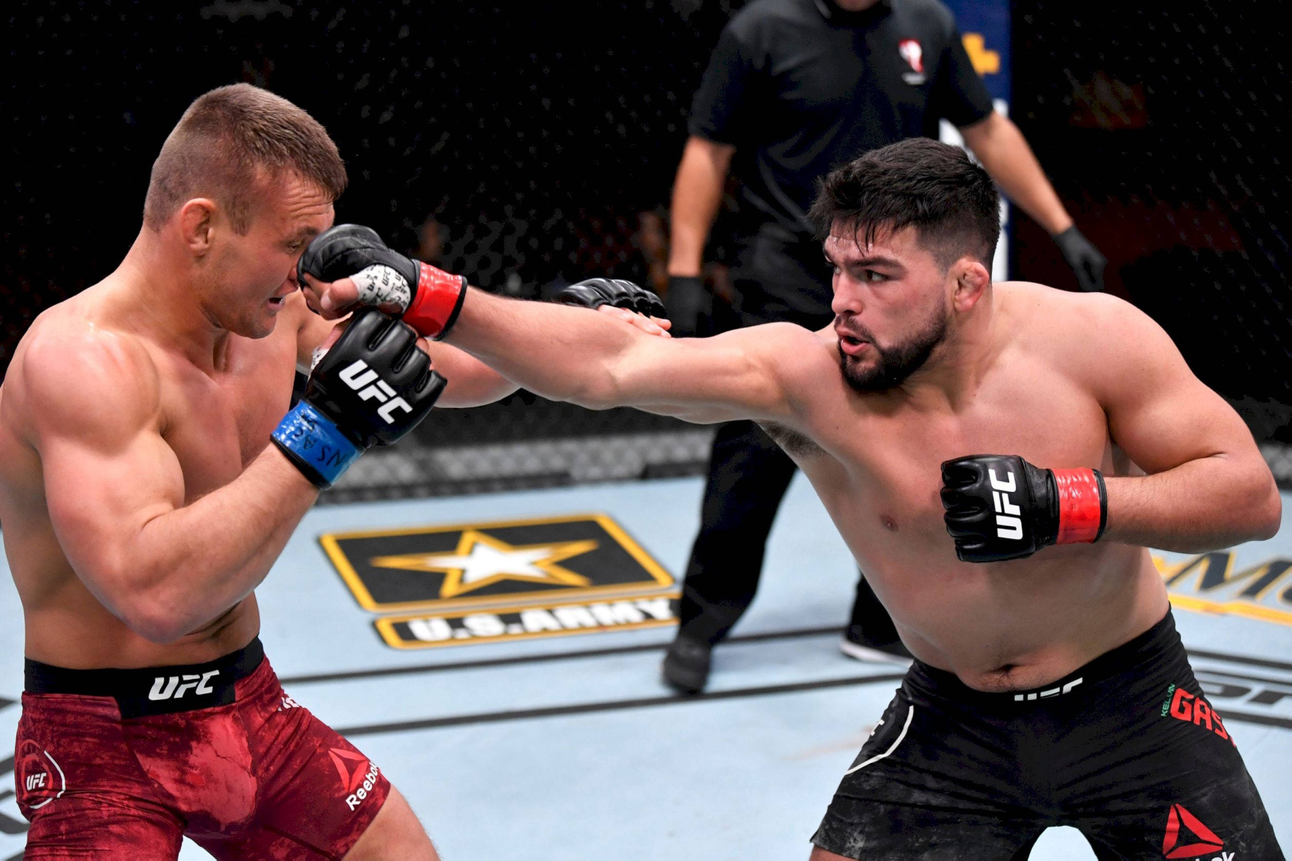 MMA 桌布 壁紙 — 兩名MMA拳手在明亮的場館燈光下進行激烈的UFC比賽，背景有裁判。