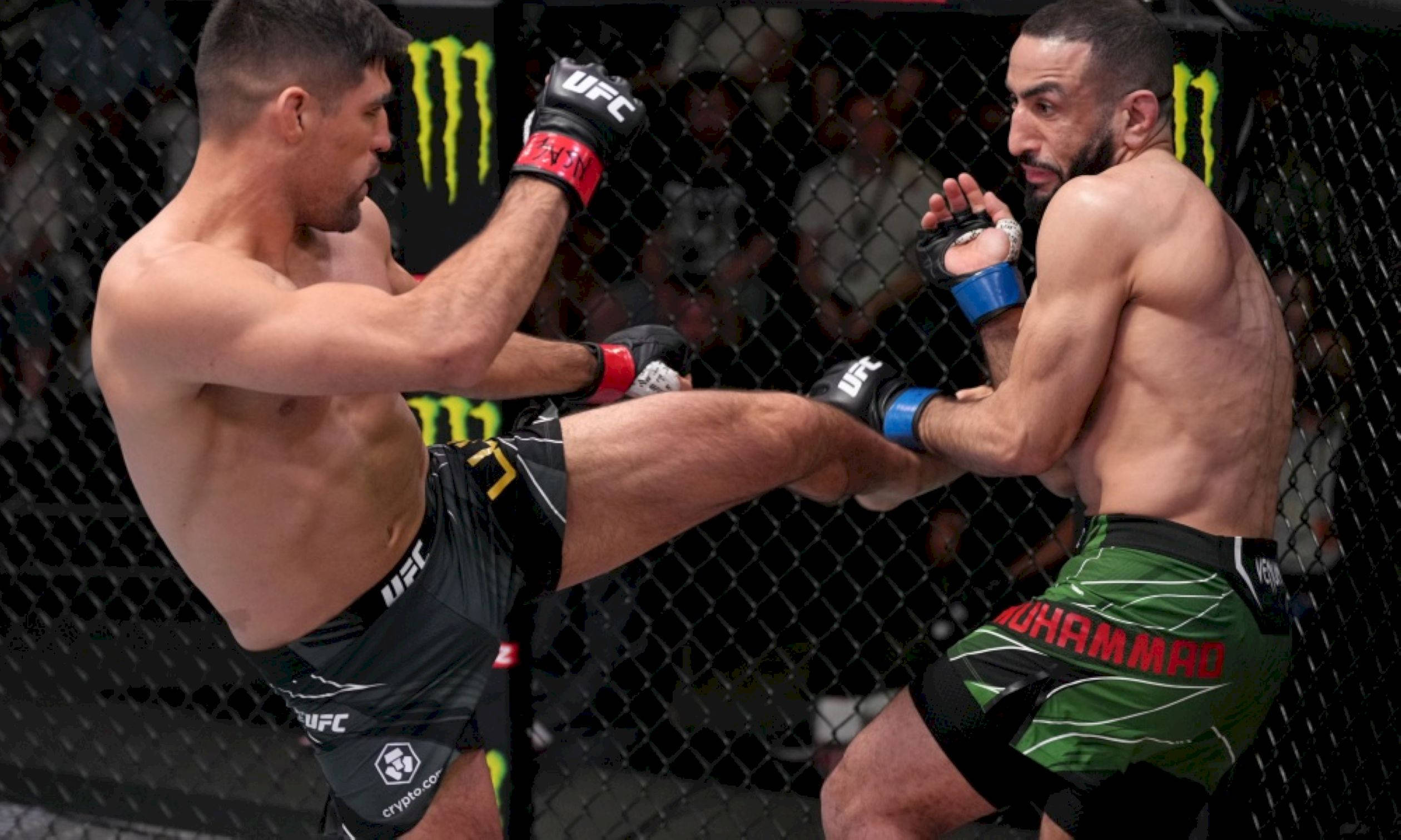 MMA 桌布 壁紙 — 兩名MMA拳手在激烈的鐵籠賽中交鋒，其中一人使出高踢，另一人防守。