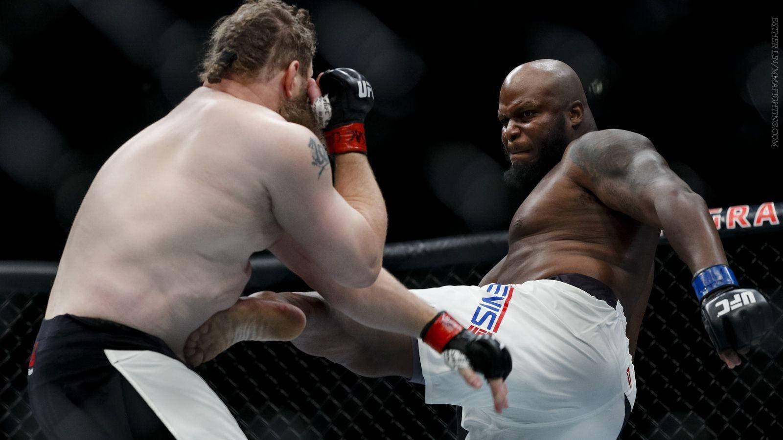 MMA 桌布 壁紙 — 兩名MMA拳手在激烈的鐵籠賽中交鋒，其中一人踢出強力一腳，另一人則進行阻擋。