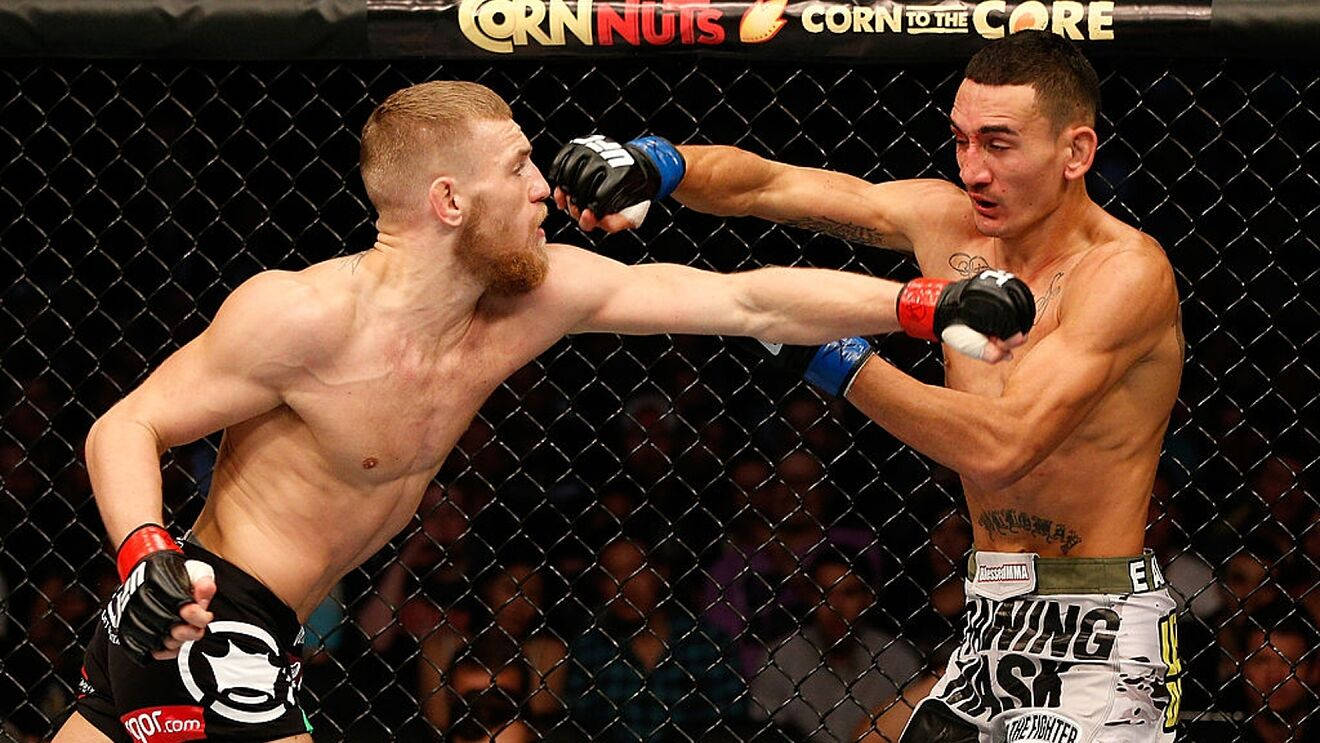 MMA 桌布 壁紙 — 兩名MMA拳手在激烈的鐵籠賽中交鋒，其中一人向對手面部猛烈出拳。