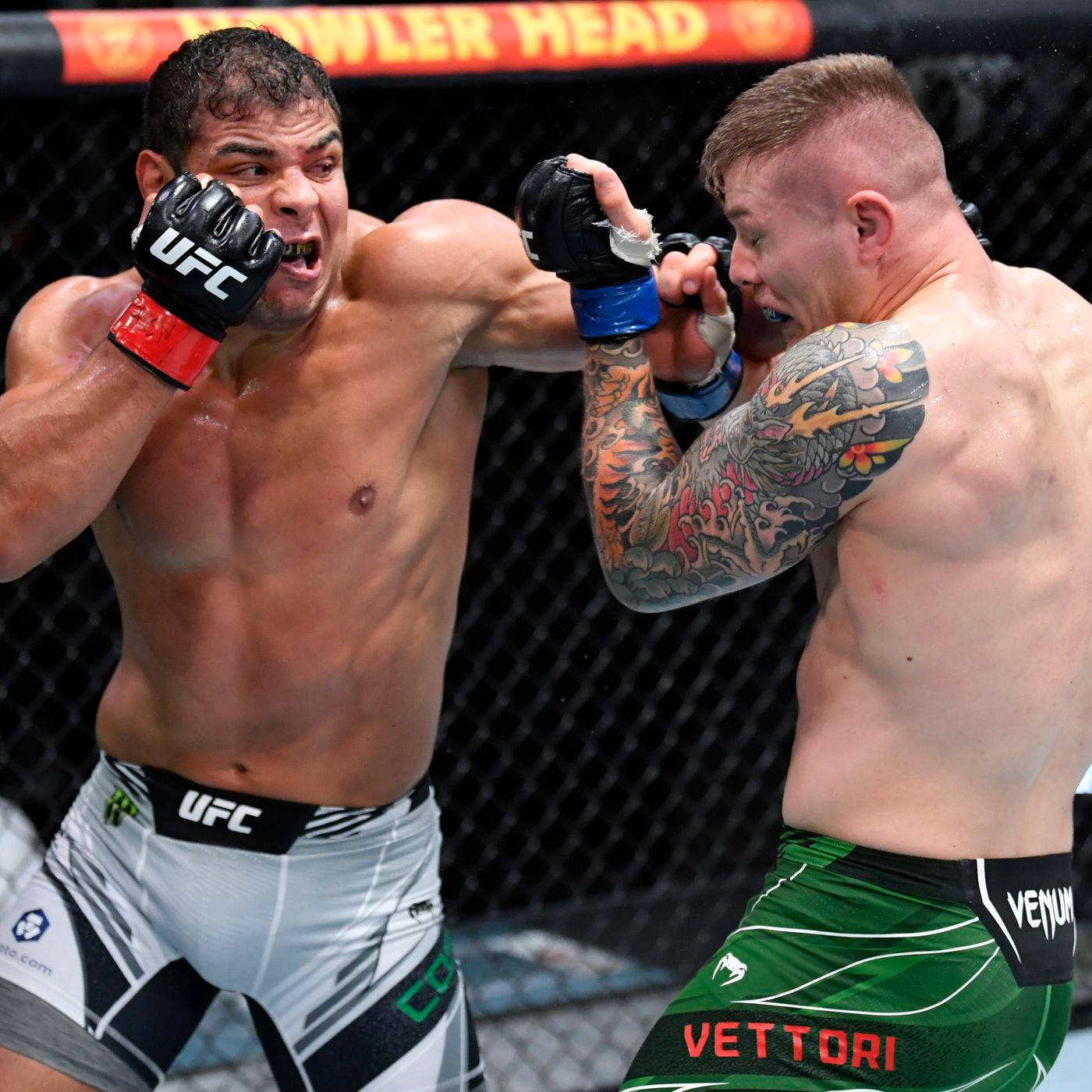 UFC 桌布 壁紙 — 兩名MMA拳手在激烈的鐵籠賽中交鋒，一人打出強力一拳，另一人則進行阻擋。