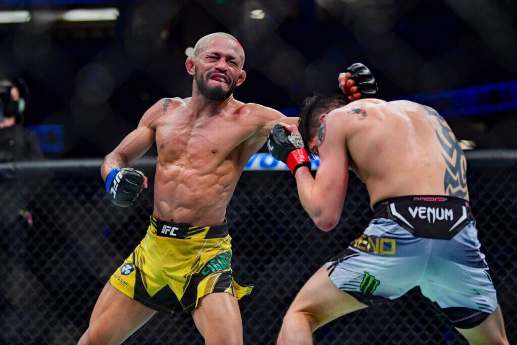 MMA 桌布 壁紙 — 兩名MMA拳手在激烈的鐵籠賽中碰撞，汗水飛濺，其中一人打出強力一拳。