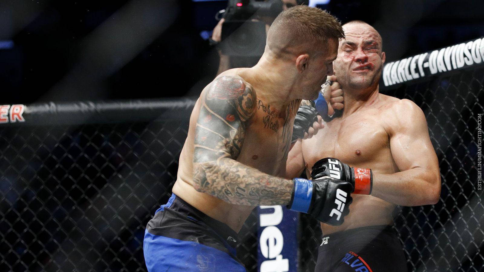 MMA 桌布 壁紙 — 兩名MMA拳手在籠中激烈纏鬥，滿臉鮮血，紋身在明亮的場館燈光下清晰可見。