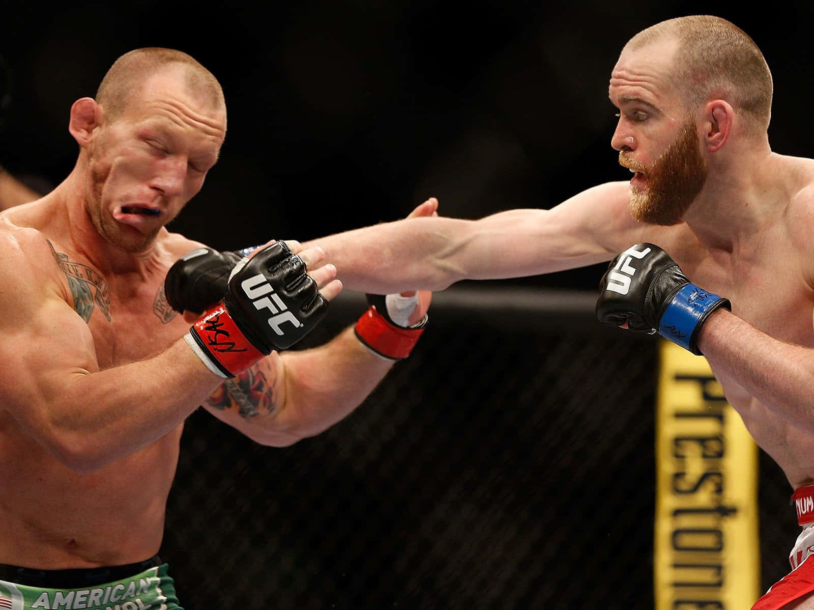 Fight 桌布 壁紙 — 兩名MMA拳手在鐵籠中交鋒，其中一人在激烈的UFC比賽中向對方臉部打出強力一拳。
