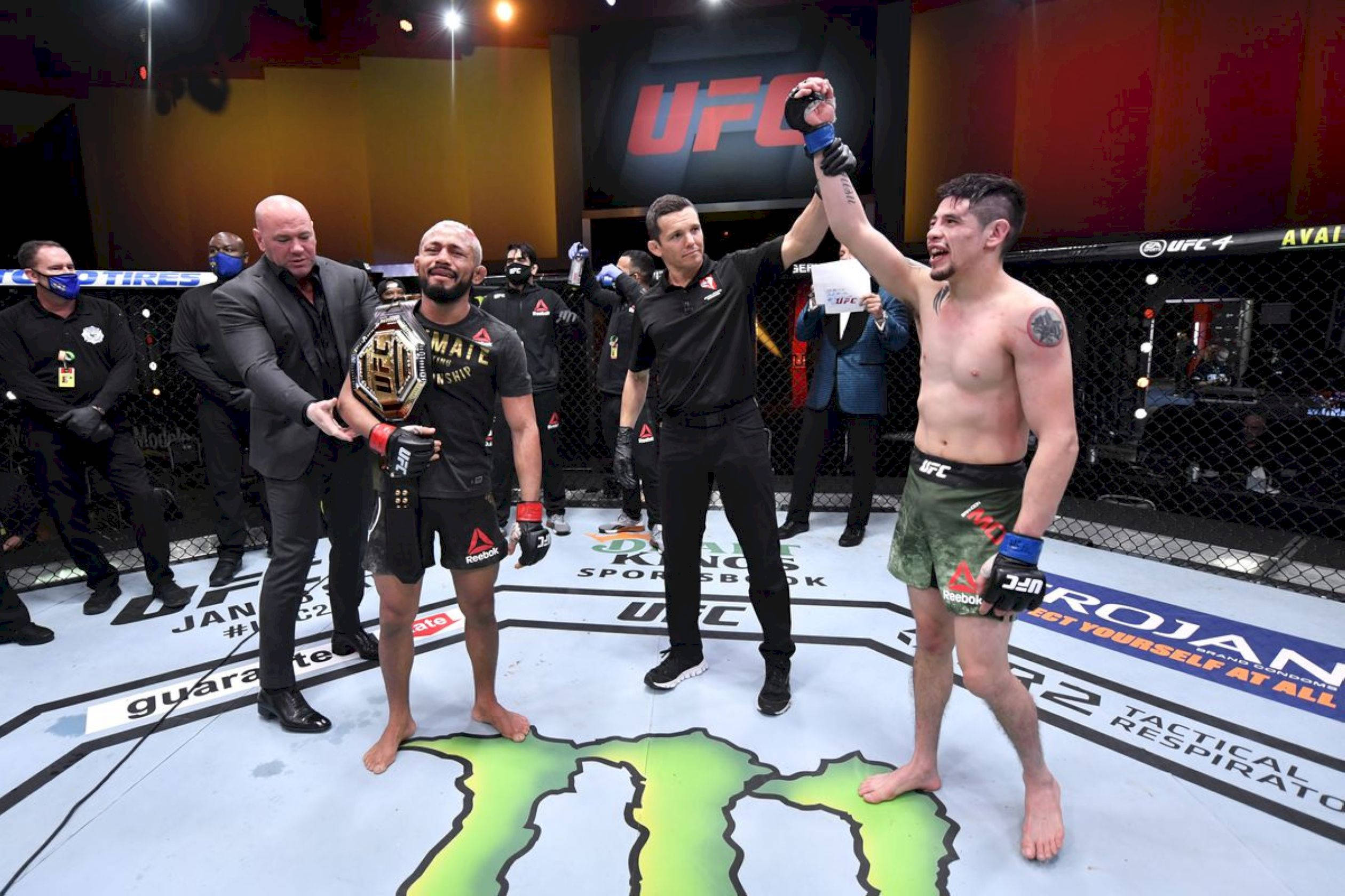 Victory 桌布 壁紙 — 兩名UFC拳手在八角籠中慶祝勝利，裁判舉起勝者的手，冠軍持有冠軍腰帶。