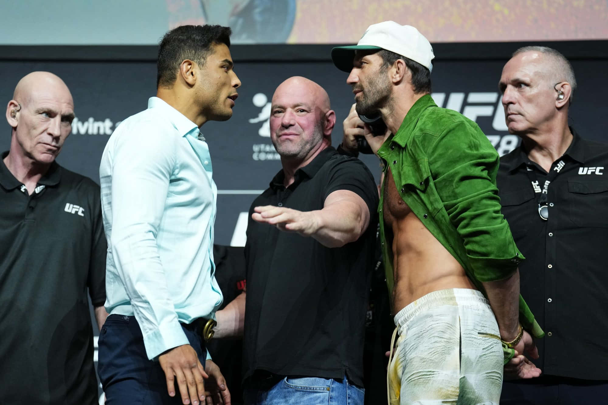 MMA 桌布 壁紙 — 兩名UFC拳手在稱重儀式上對峙，官員在兩旁，場館燈光璀璨。