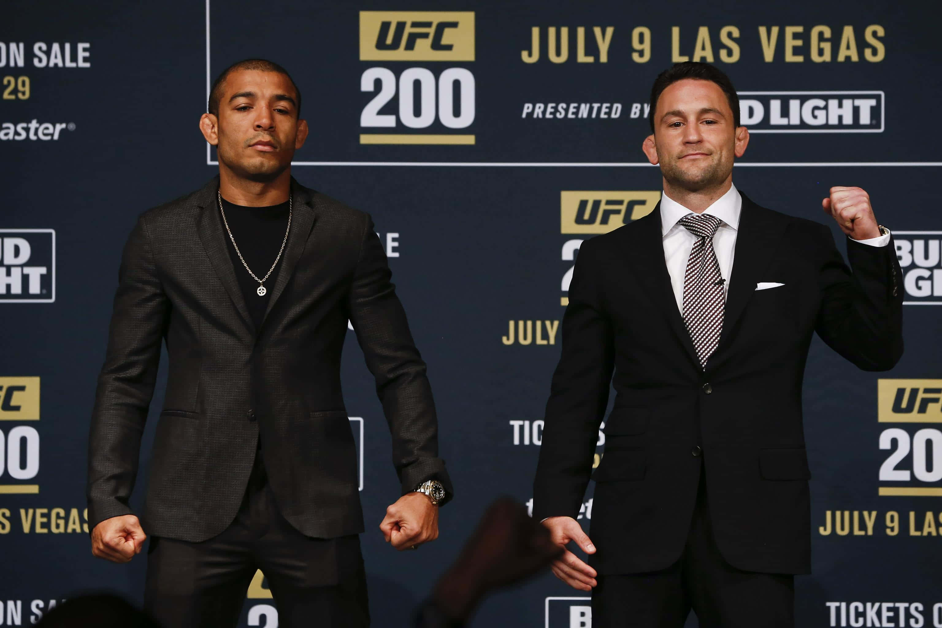 UFC 桌布 壁紙 — 兩名UFC拳手在記者會上自信地站立，身後有冠軍橫幅。
