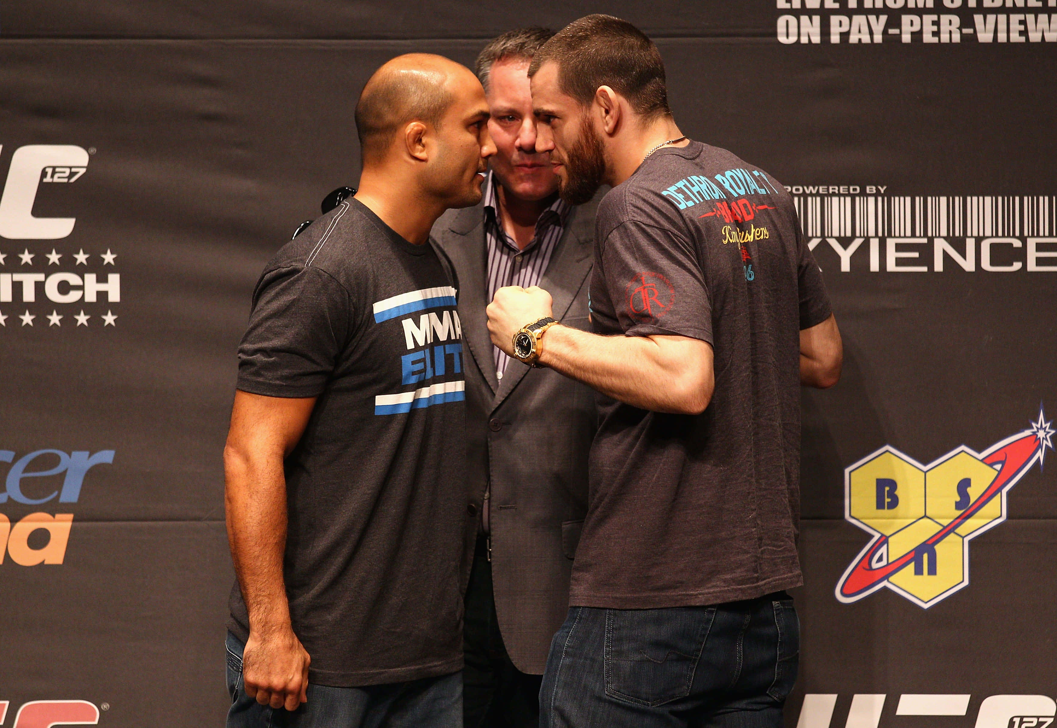 UFC 桌布 壁紙 — 兩名UFC拳手在記者會上進行緊張的賽前對峙，中間有裁判。