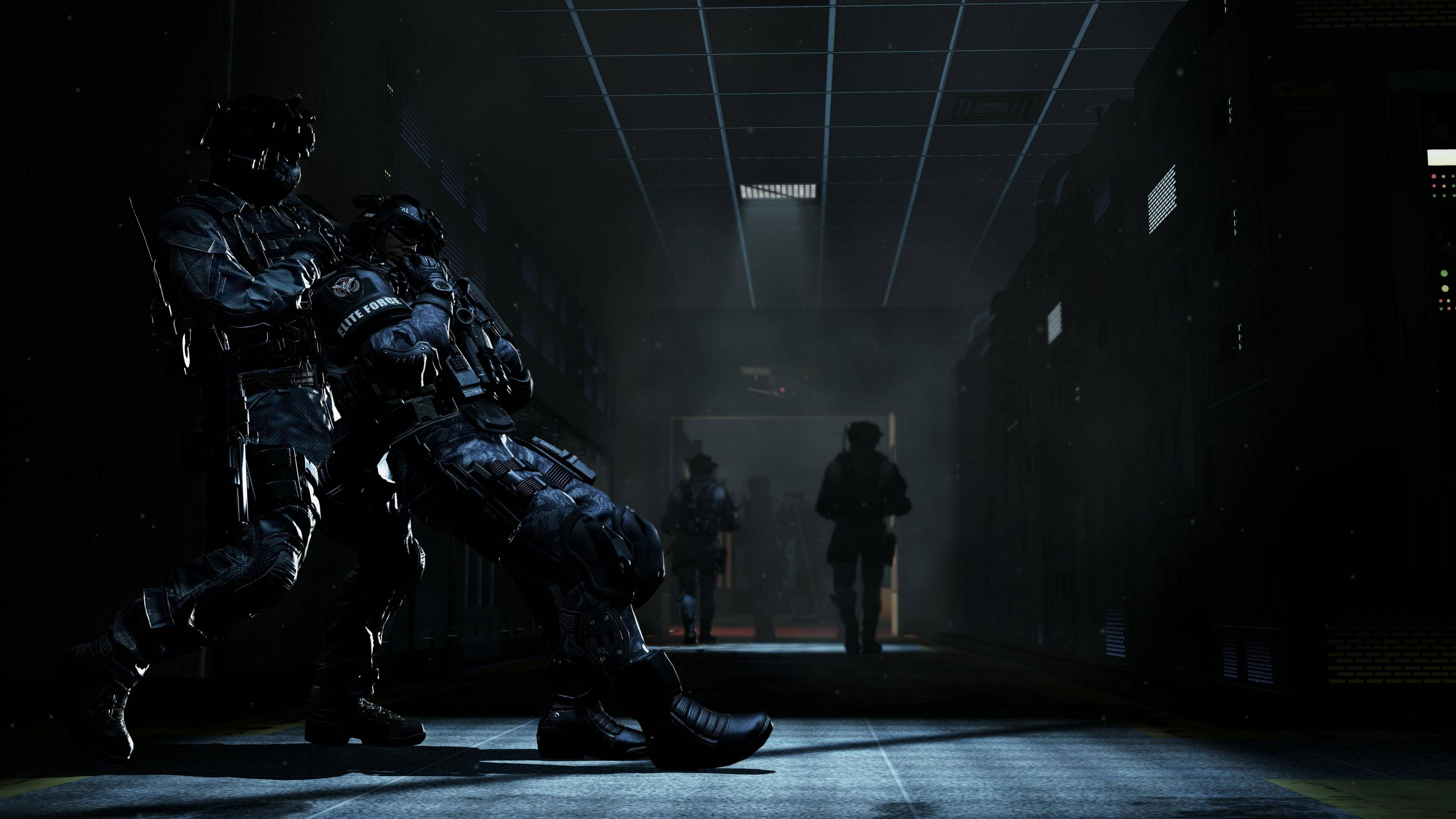 4K call of duty 桌布 壁紙 — 兩名全副武裝的士兵在昏暗的工業走廊中前進，遠處有模糊的人影在霧中。