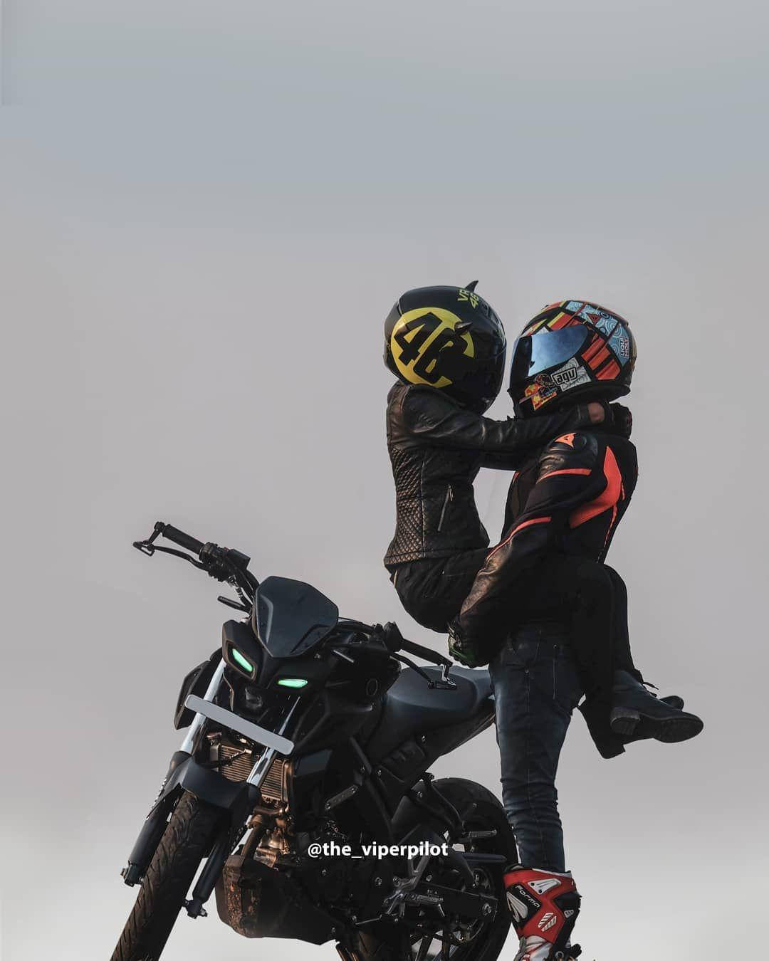 Couple 桌布 壁紙 — 兩名全副裝備的機車騎士在黑色機車上熱情擁抱，背景是朦朧的天空。