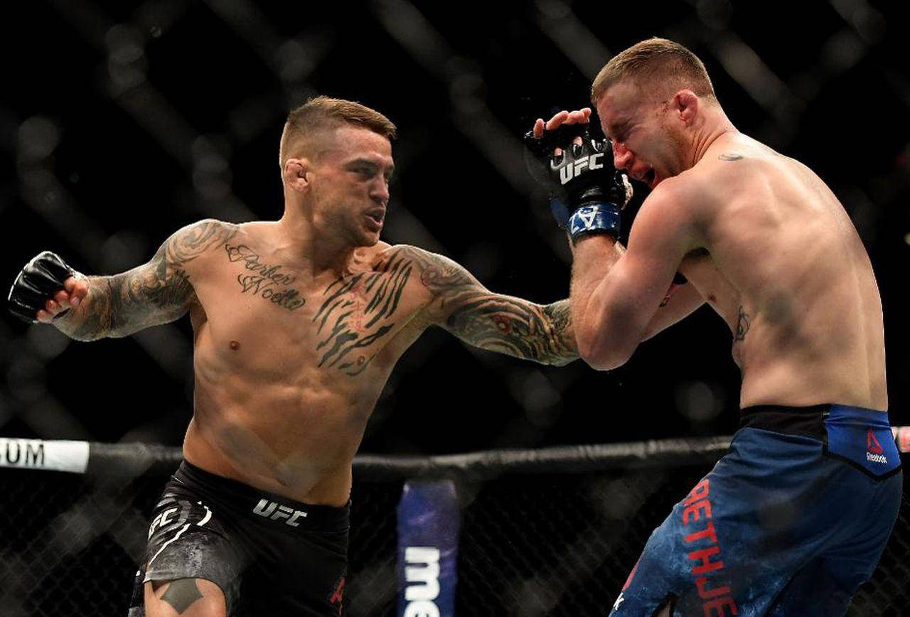MMA 桌布 壁紙 — 兩名刺青MMA拳手在籠中激戰，其中一人向對手臉部重擊一拳。