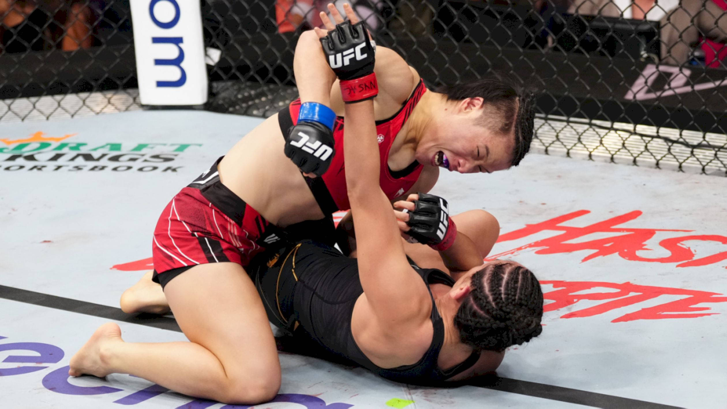 Punch 桌布 壁紙 — 兩名女子MMA拳手在UFC八角籠墊上激烈纏鬥，其中一人施展鎖喉技。