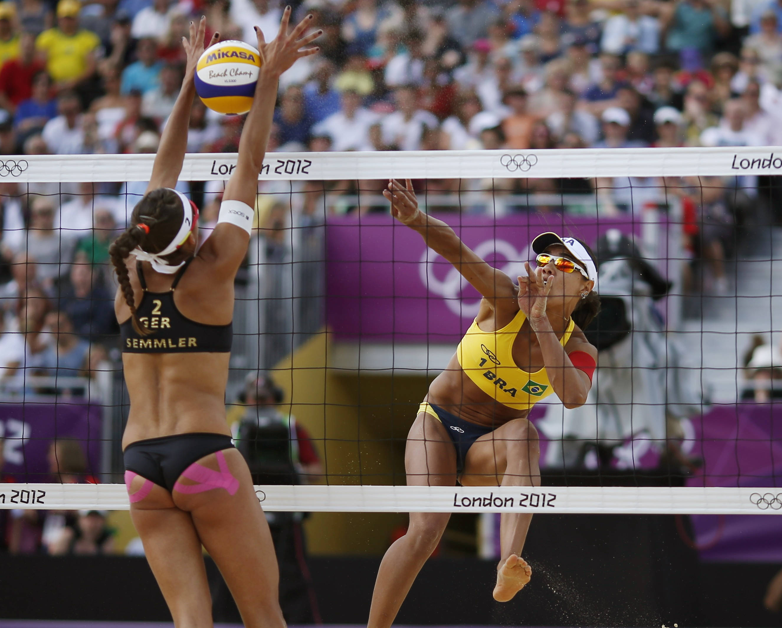 volleyball 4K 桌布 壁紙 — 兩名女子沙灘排球選手在2012年倫敦奧運會期間在網前激烈競爭中跳躍。