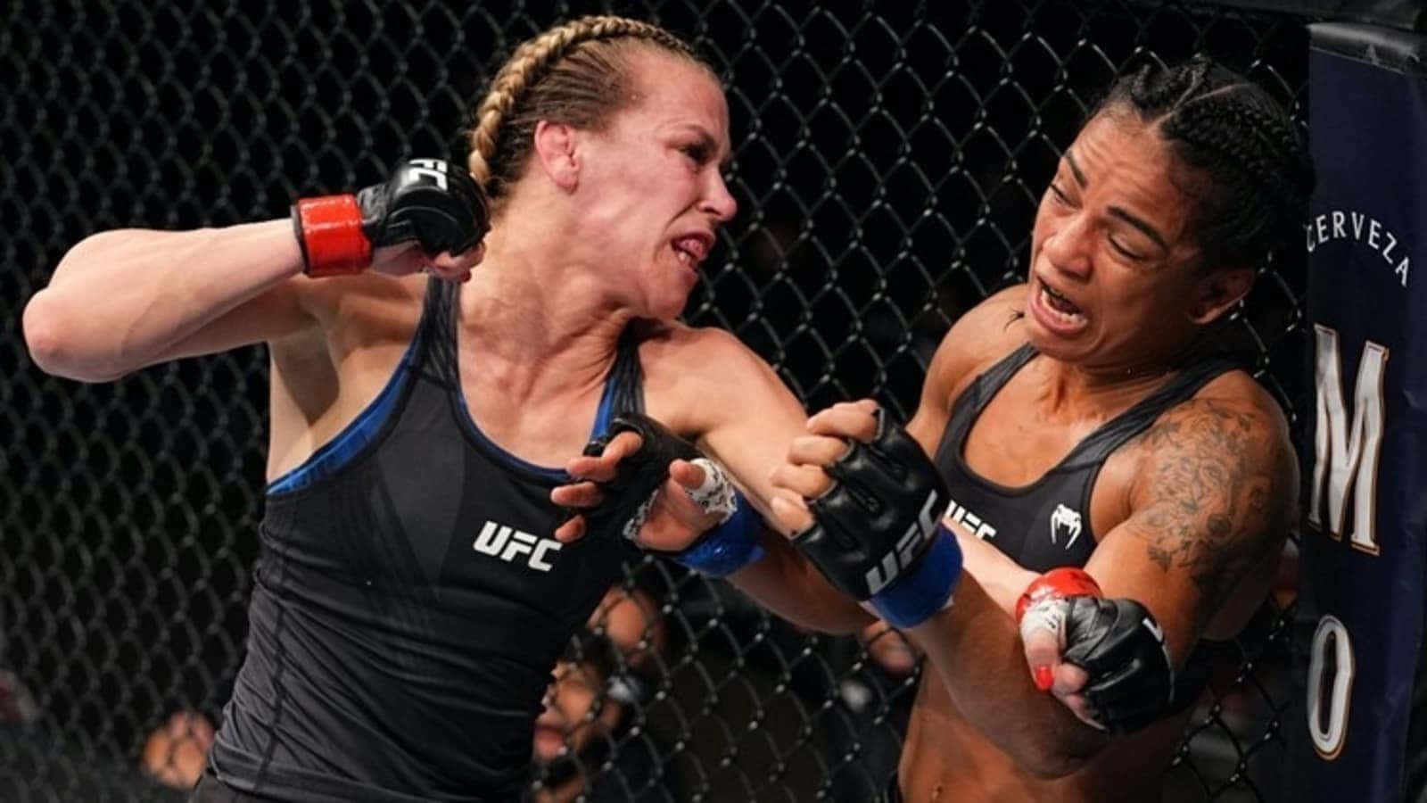 桌布 壁紙 — 兩名女性MMA拳手在UFC八角籠中激烈交鋒，背景為鐵絲網圍欄。