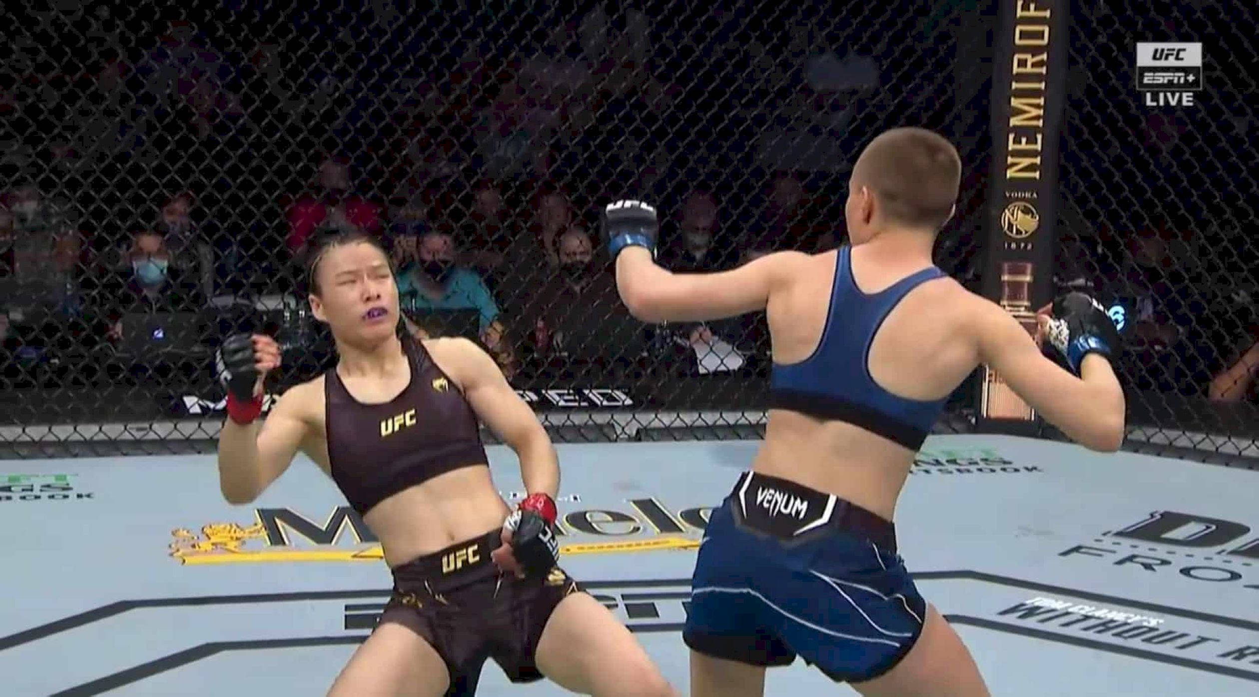 Punch 桌布 壁紙 — 兩名女性MMA拳手在八角籠中交鋒，其中一人打出強力一拳，另一人則準備承受衝擊。