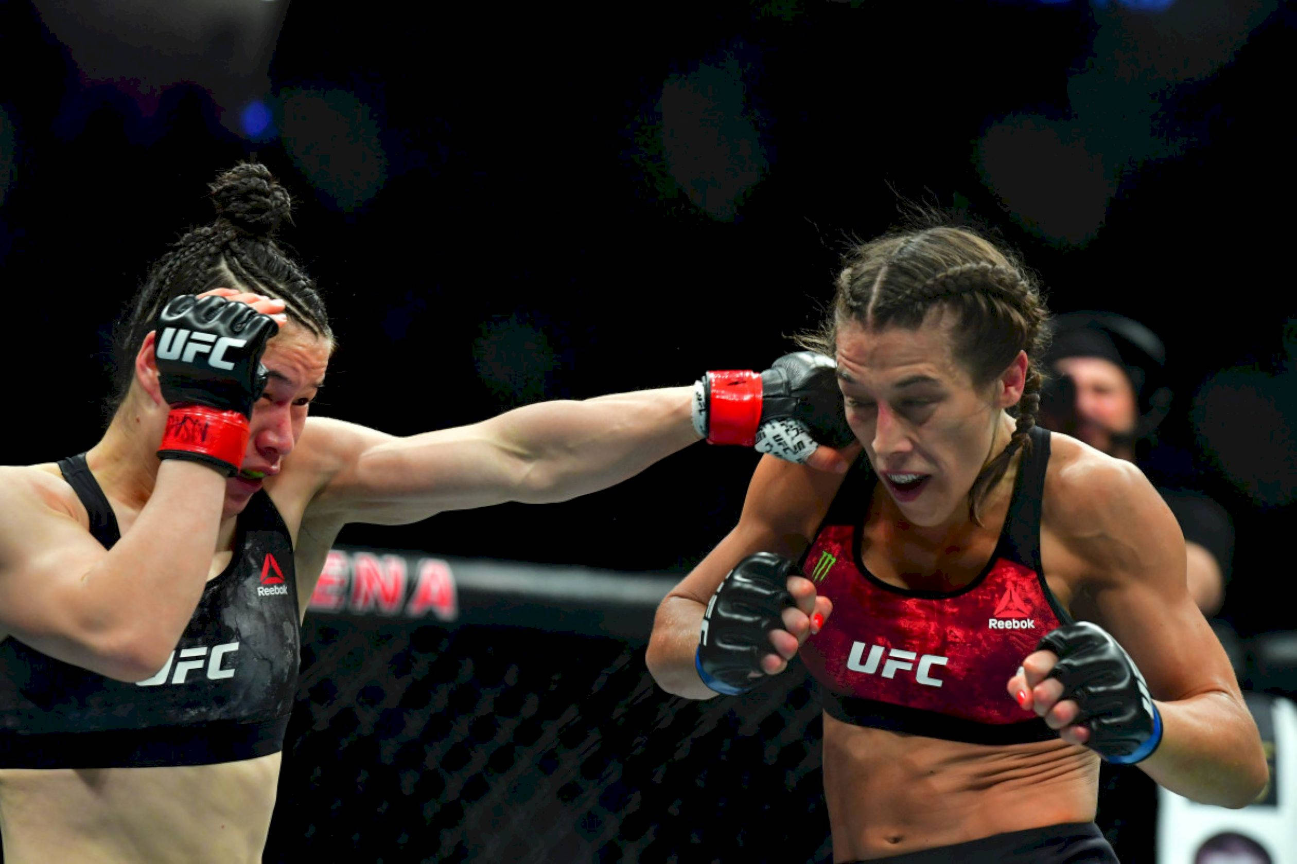 Punch 桌布 壁紙 — 兩名女性MMA拳手在八角籠中激烈交鋒，手套飛舞，汗水四濺。