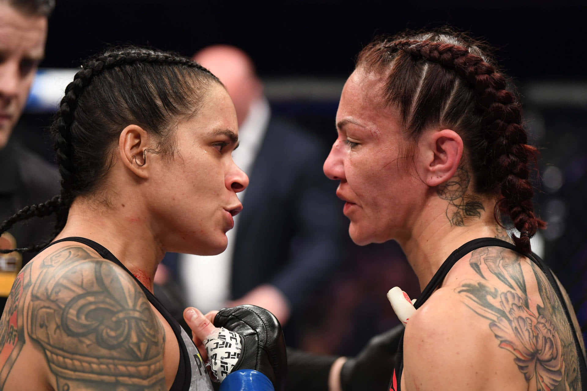 MMA 桌布 壁紙 — 兩名女性MMA拳手在八角籠內激烈對峙，紋身和手套清晰可見。