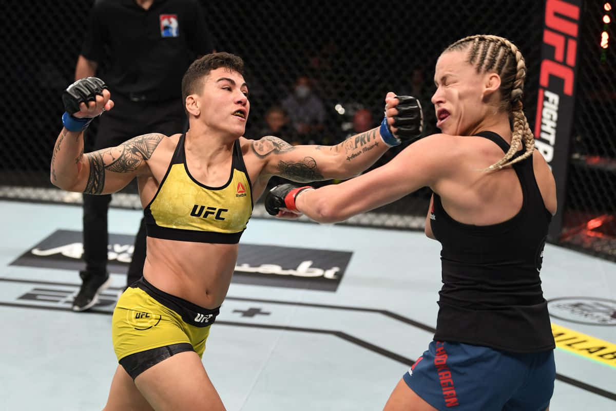 UFC 桌布 壁紙 — 兩名女性MMA拳手在激烈的UFC八角籠比賽中碰撞，帶有刺青和專注的表情。