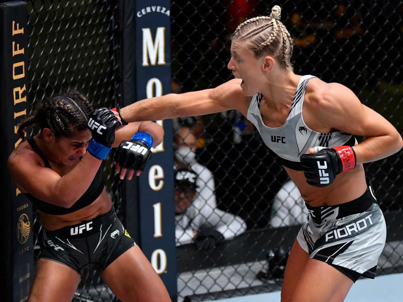 桌布 壁紙 — 兩名女性MMA拳手在激烈的UFC八角籠比賽中交鋒，其中一人打出強力一拳。