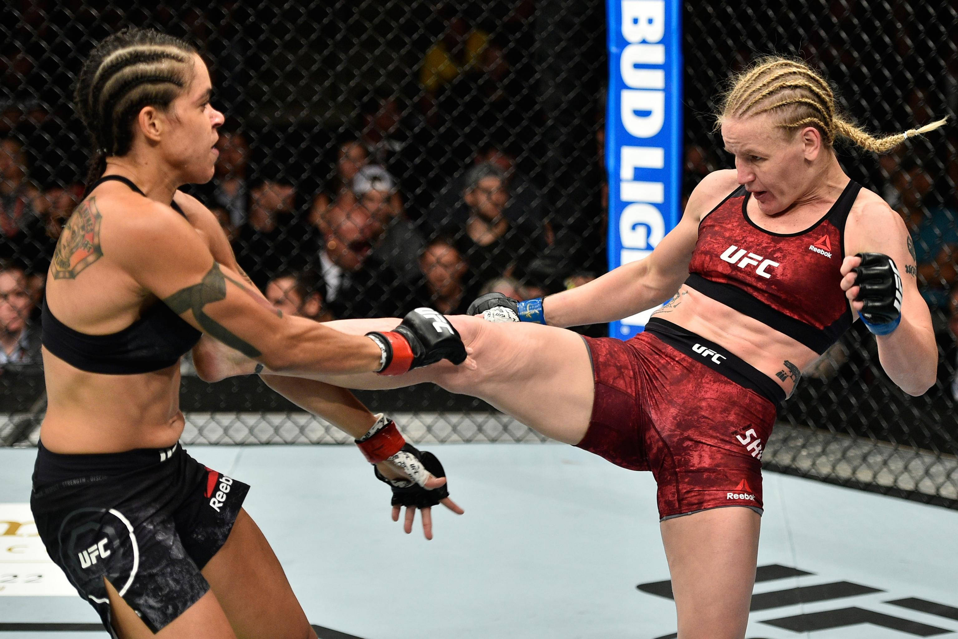 UFC 桌布 壁紙 — 兩名女性MMA拳手在激烈的籠鬥中交鋒，其中一人使出高踢。