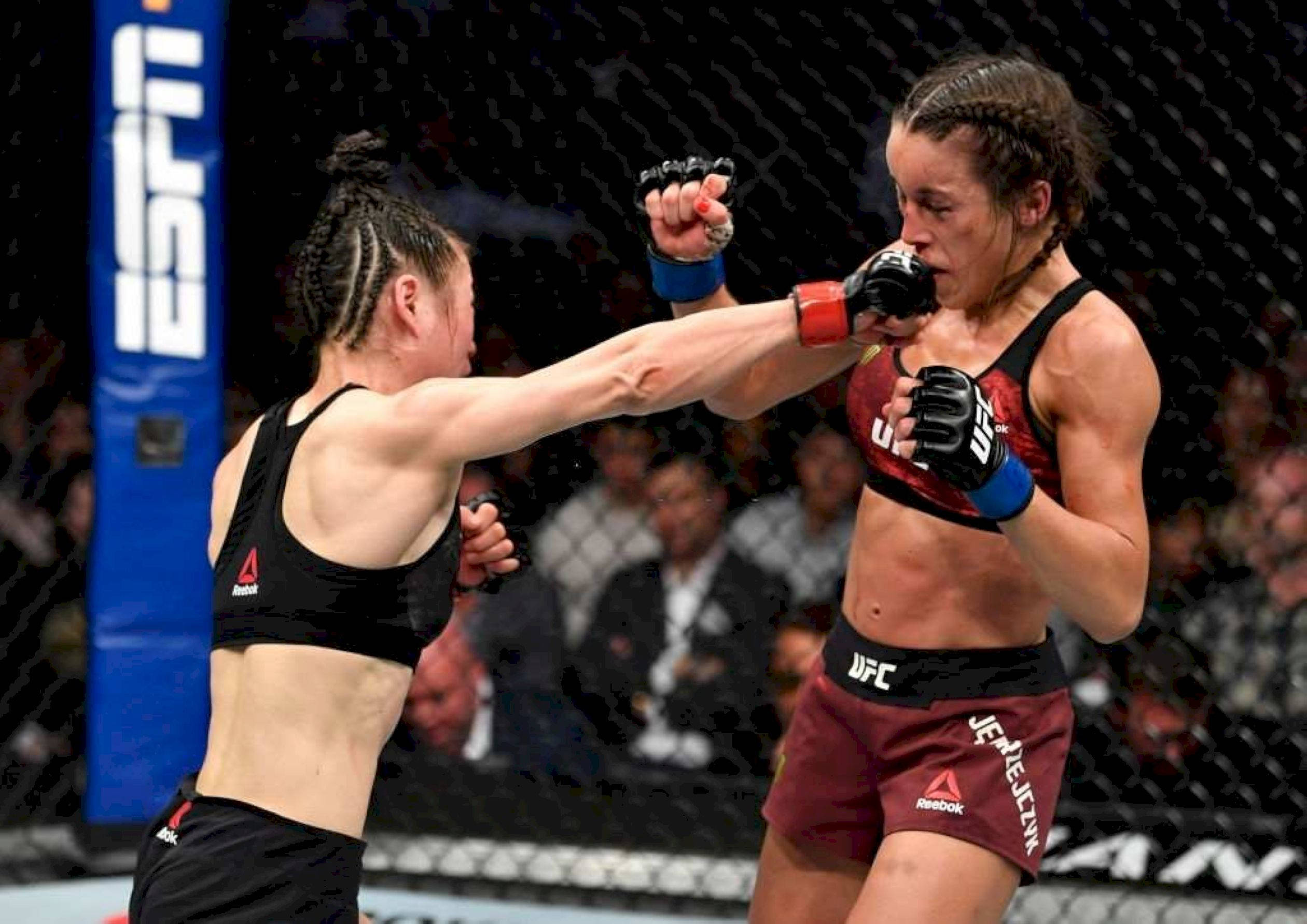 Punch 桌布 壁紙 — 兩名女性MMA拳手在激烈的籠鬥中碰撞，拳頭飛舞，汗水飛濺。