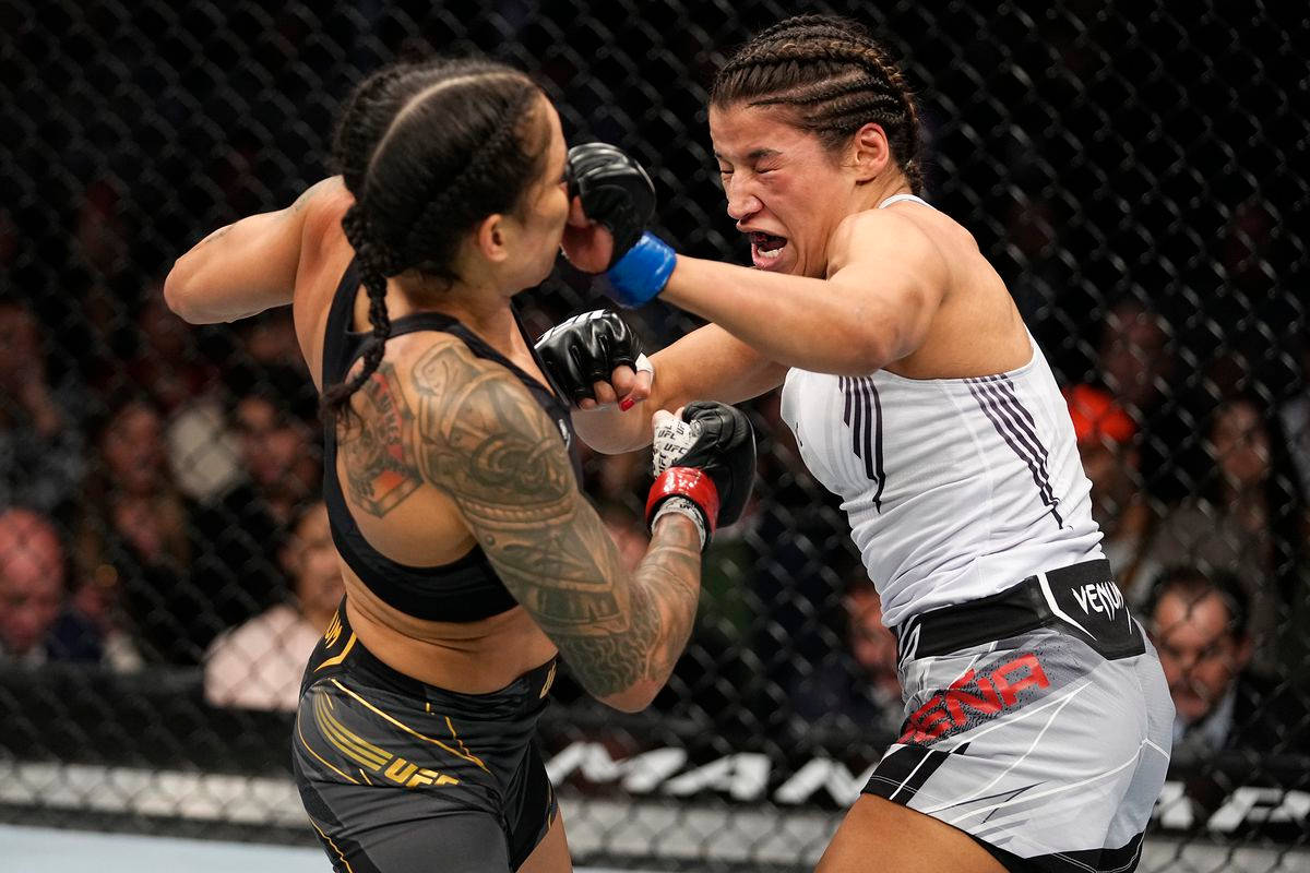UFC 桌布 壁紙 — 兩名女性MMA拳手在激烈的鐵籠賽中交鋒，其中一人打出強力一拳。