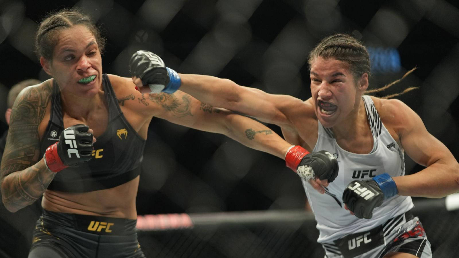 UFC 桌布 壁紙 — 兩名女性UFC拳手在八角籠內激烈近距離交鋒，表情專注，手臂有刺青。