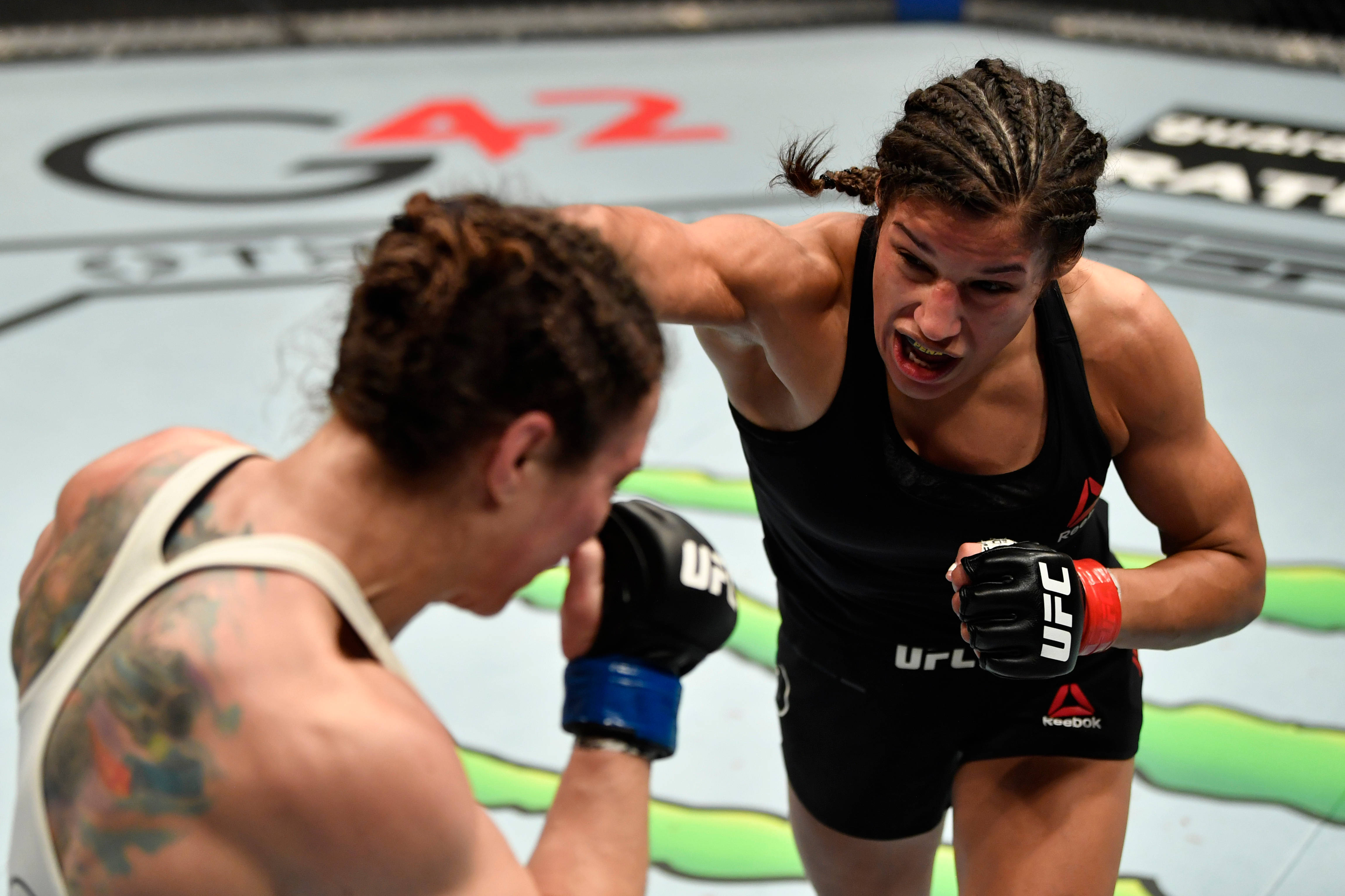 UFC 桌布 壁紙 — 兩名女拳手在UFC八角籠中交鋒，其中一人打出強力一拳，另一人防守。