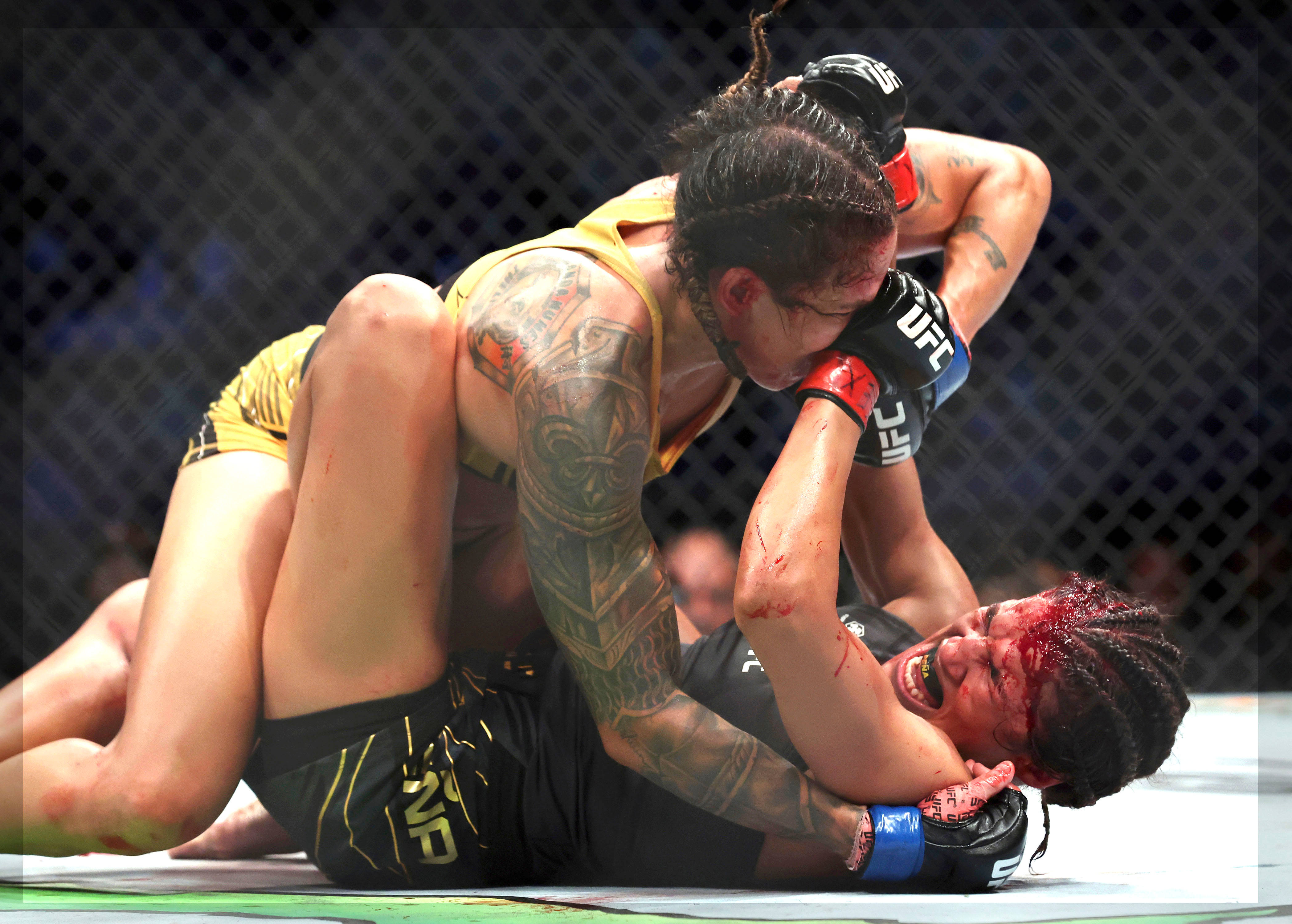MMA 桌布 壁紙 — 兩名女拳手在UFC八角籠中激烈纏鬥，滿臉鮮血，手臂有刺青。