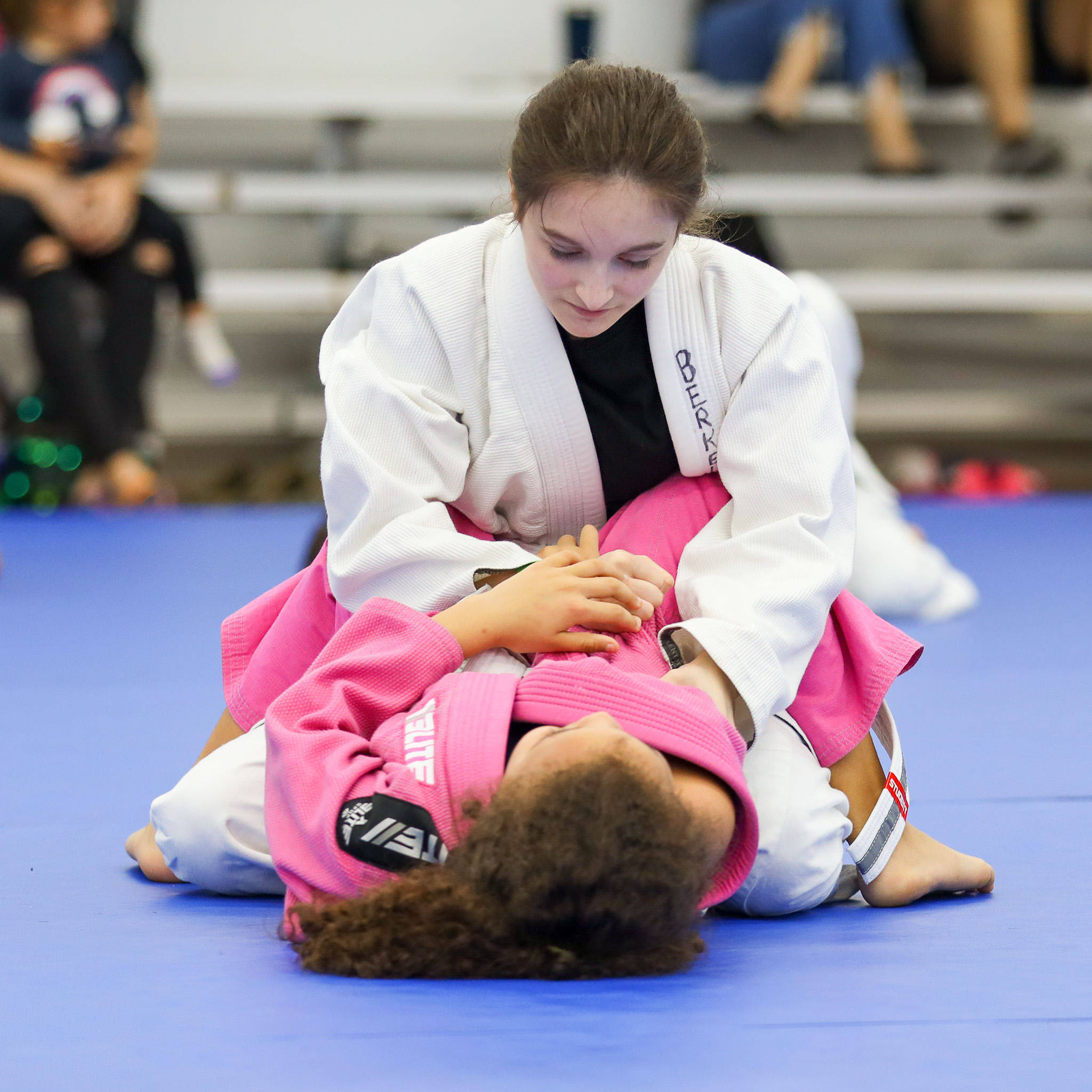 martial arts 桌布 壁紙 — 兩名女柔道選手在藍色墊子上進行激烈纏鬥的比賽。