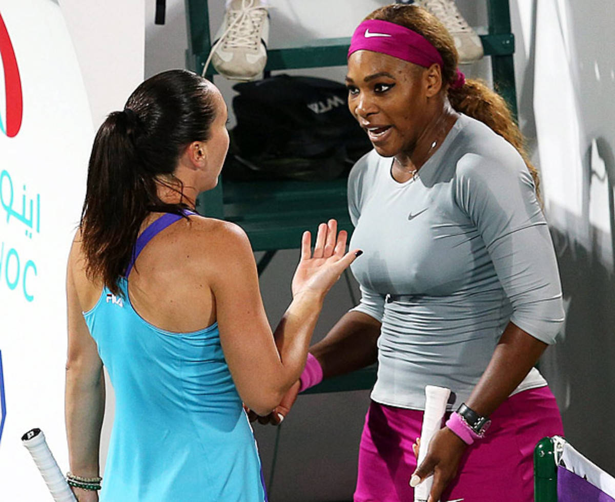 Tennis 桌布 壁紙 — 兩名女網球運動員在球場上友好地擊掌，穿著鮮豔的運動服和可見的裝備。