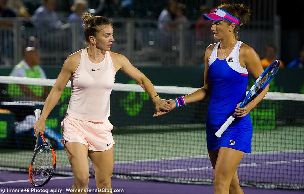Tennis 桌布 壁紙 — 兩名女網球選手在紫色球場上，於體育館燈光下隔網握手。