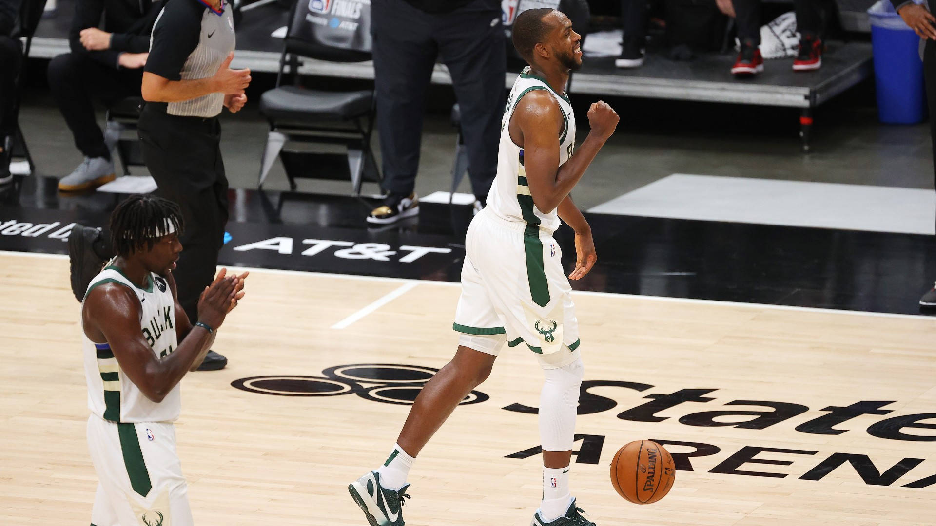 Khris Middleton 桌布 壁紙 — 兩名密爾瓦基公鹿籃球運動員在硬木球場上慶祝，附近有一個籃球滾動。
