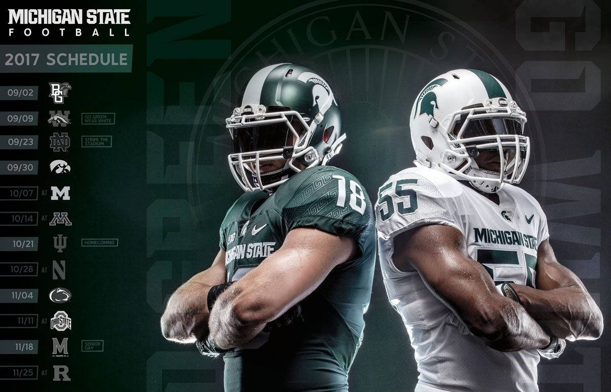 Michigan State Spartans 桌布 壁紙 — 兩名密西根州立大學足球員身穿綠色和白色球衣，自信地交叉雙臂，站在帶有2017年賽程的深色背景前。