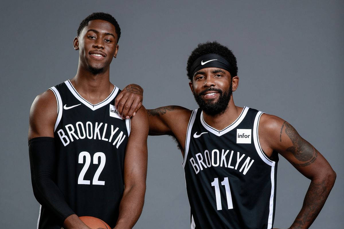 caris levert 桌布 壁紙 — 兩名布魯克林籃網隊的籃球運動員身穿黑色球衣，面帶微笑，在灰色攝影棚背景下自信地擺出姿勢。