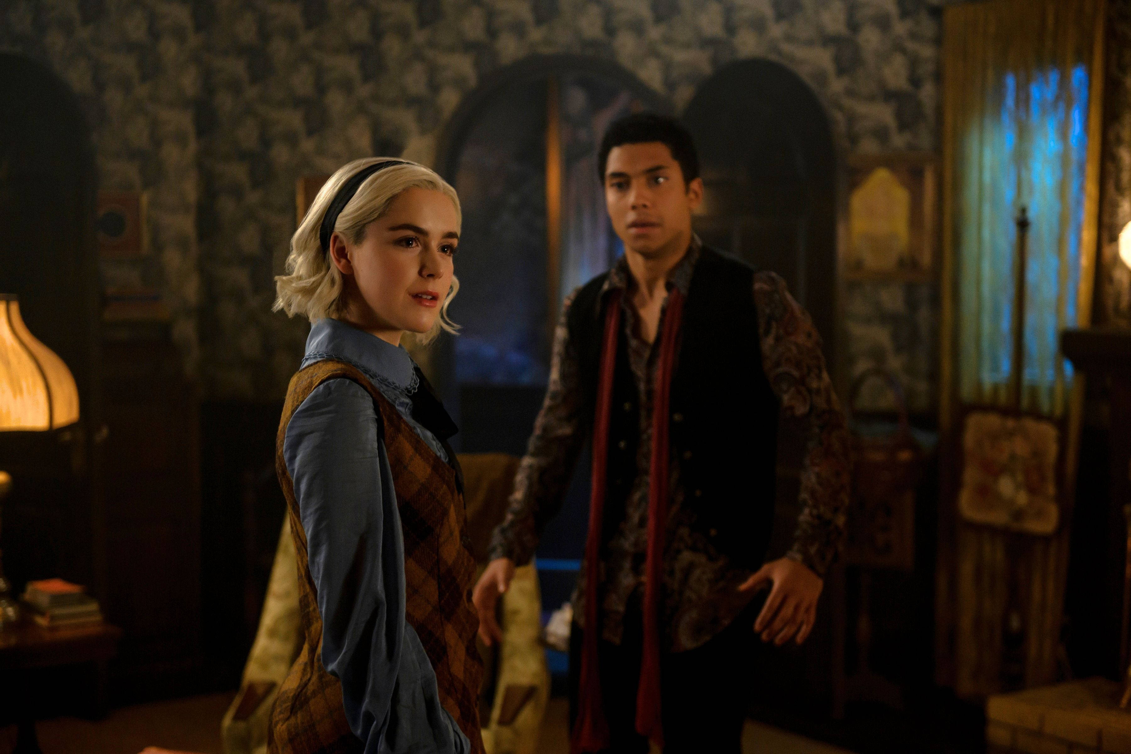 actor 桌布 壁紙 — 兩名年輕成年人站在光線昏暗的復古房間中，房間內有華麗的壁紙和溫暖的燈光，投射出柔和的陰影。