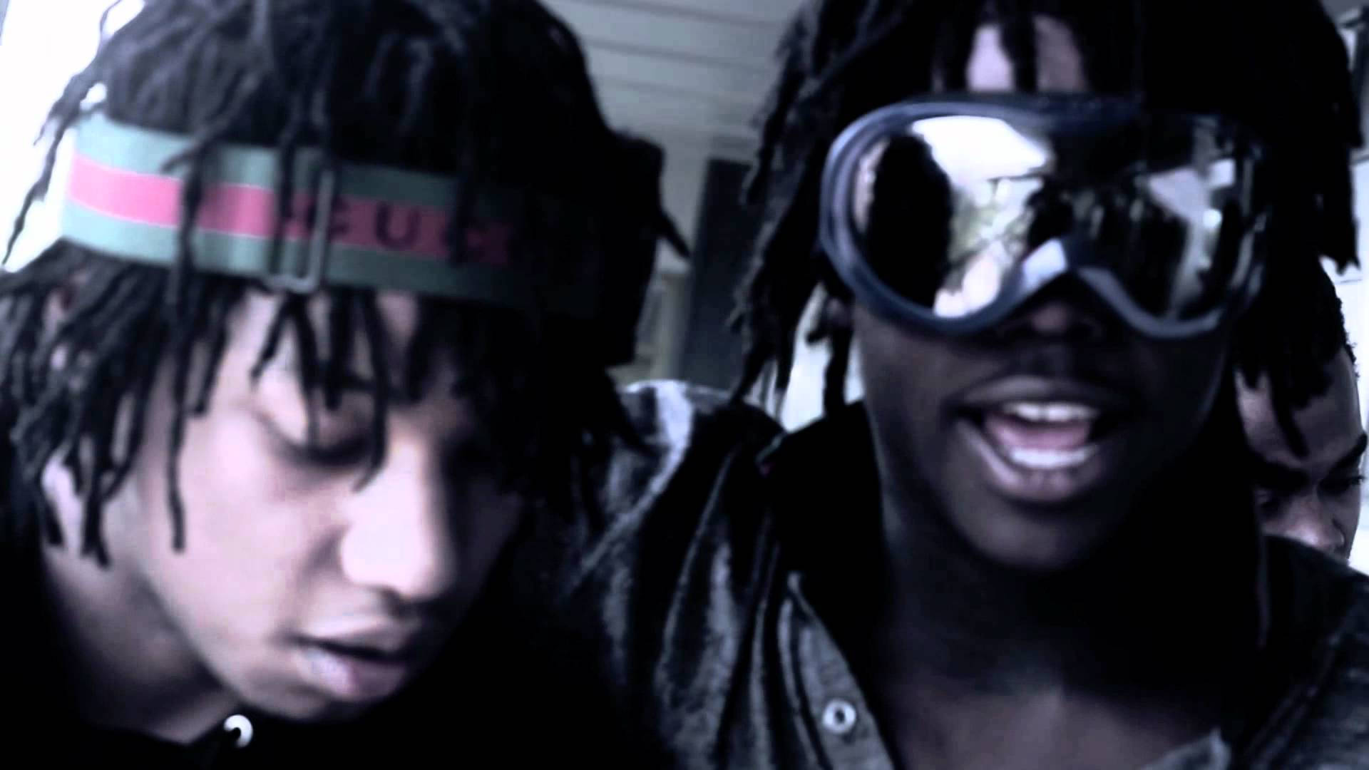 Chief Keef 桌布 壁紙 — 兩名年輕男子留著辮子，一人戴著Gucci頭帶，另一人戴著大型滑雪護目鏡，兩人在昏暗的房間裡低頭看著。