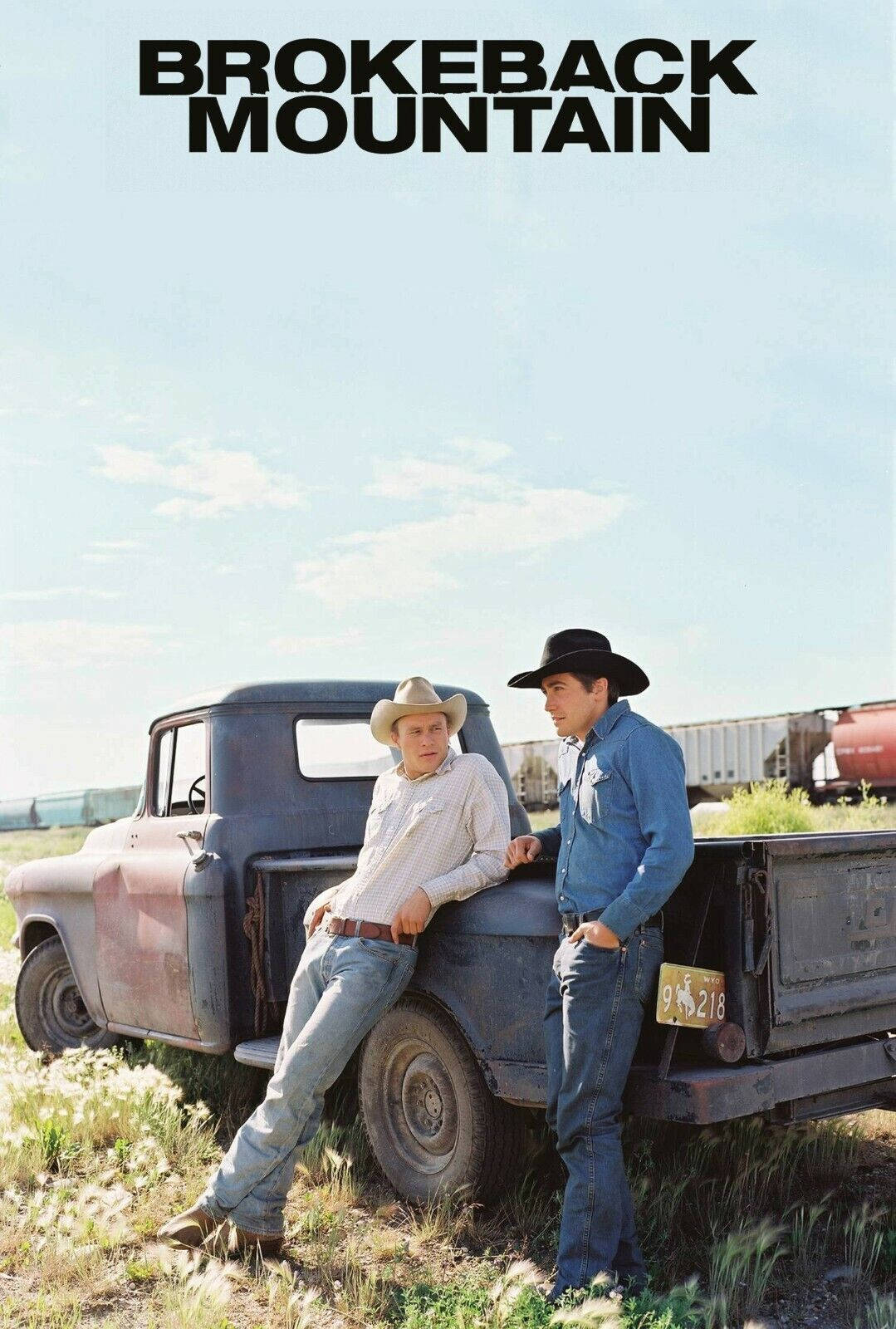 brokeback mountain 桌布 壁紙 — 兩名戴牛仔帽的男子在陽光明媚的田野中靠在一輛生鏽的皮卡車上，遠處有一列火車。