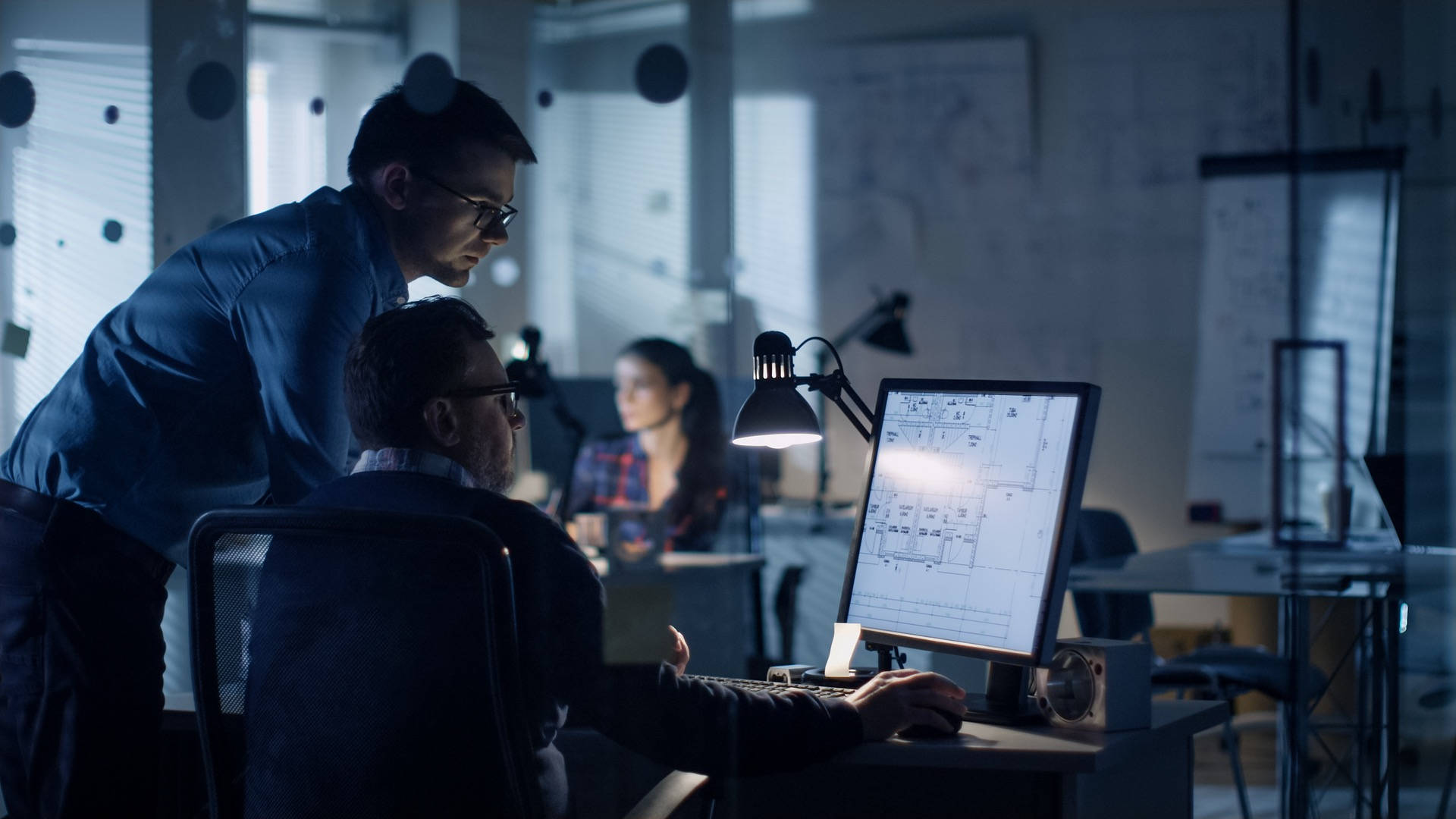 engineering 桌布 壁紙 — 兩名戴眼鏡的男子在夜間光線昏暗的現代辦公室中，在發光的顯示器上審查藍圖。