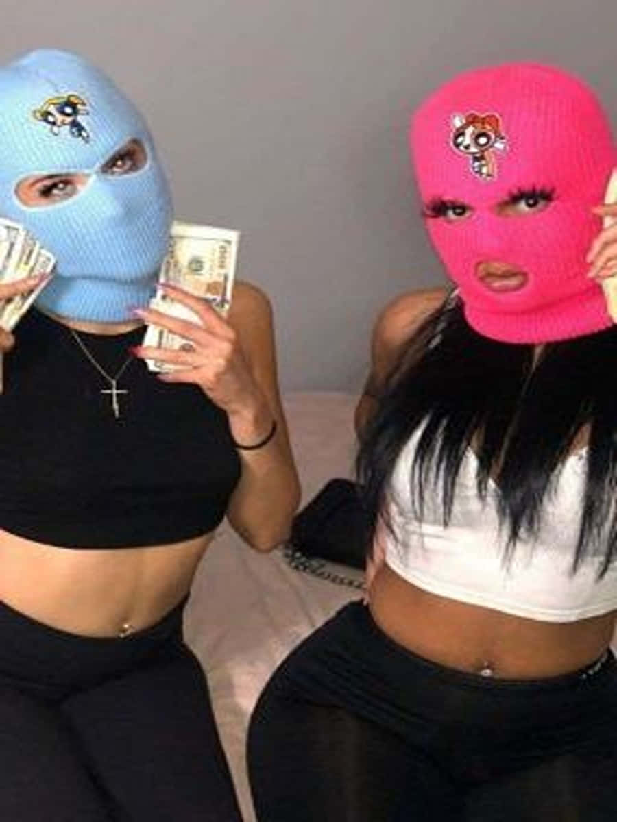 Ski Mask Girl 桌布 壁紙 — 兩名戴著色彩繽紛的飛天小女警頭套的女子在床上擺姿勢，手持一疊疊現金。