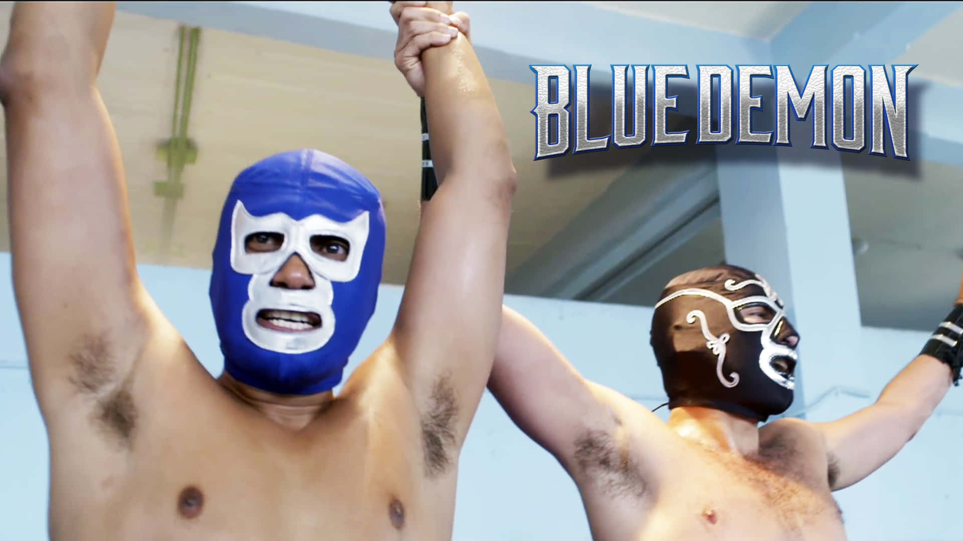 Mexican 桌布 壁紙 — 兩名戴著藍色和棕色面具的蒙面摔角手在「BLUE DEMON」標誌下高舉雙臂勝利。